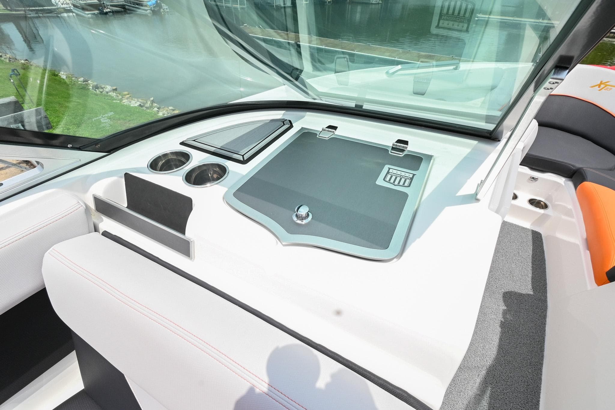 2018 MasterCraft XT23 boat dashboard with storage compartment and cup holders.