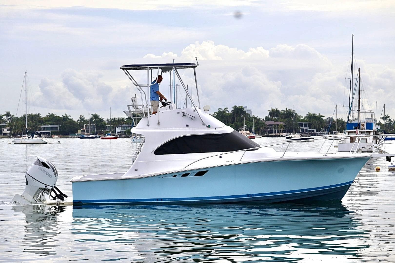 1994 Luhrs 32 Convertible boat on calm water with a person on deck.