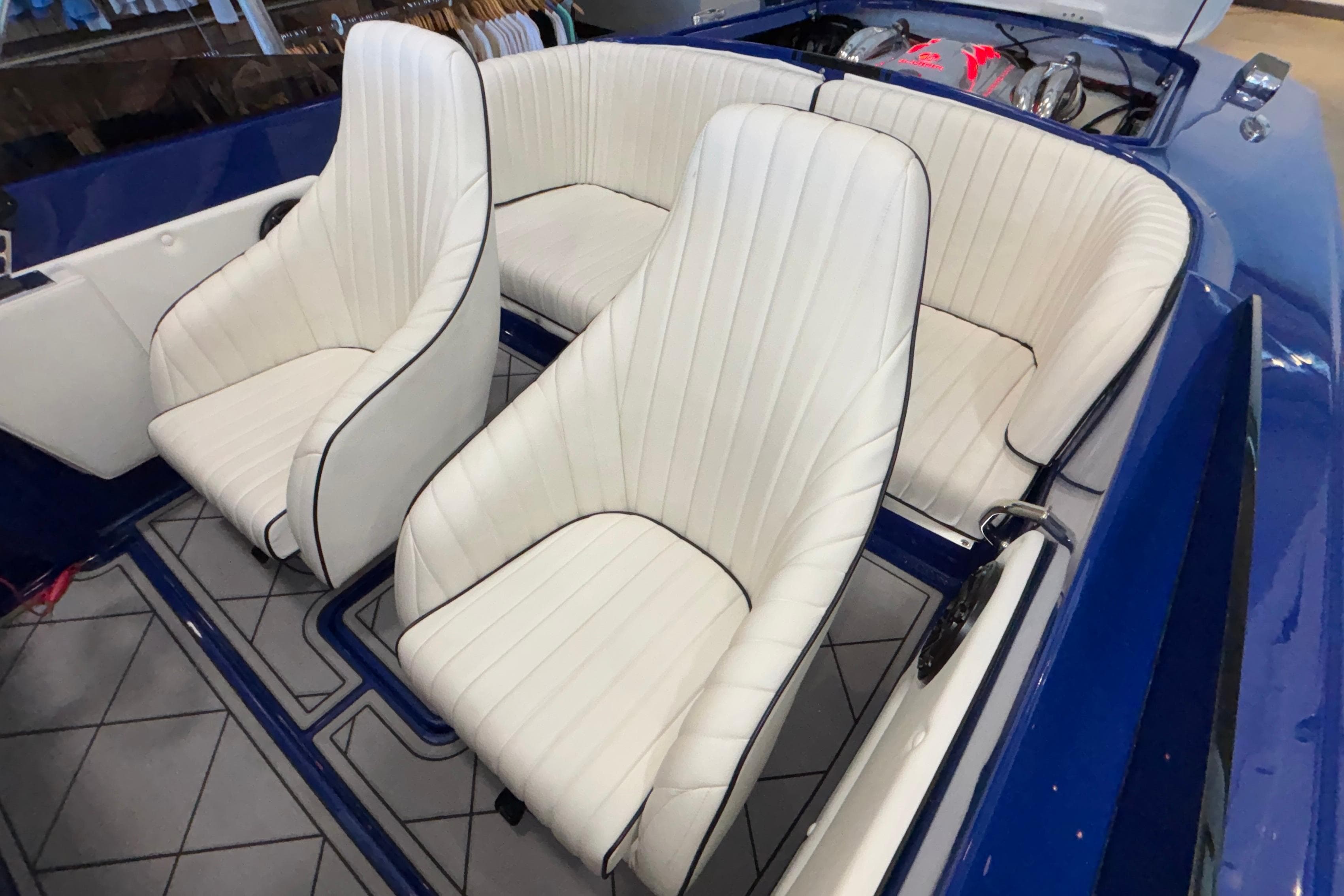 2026 Donzi 22 Classic boat interior with white leather seats and blue accents.