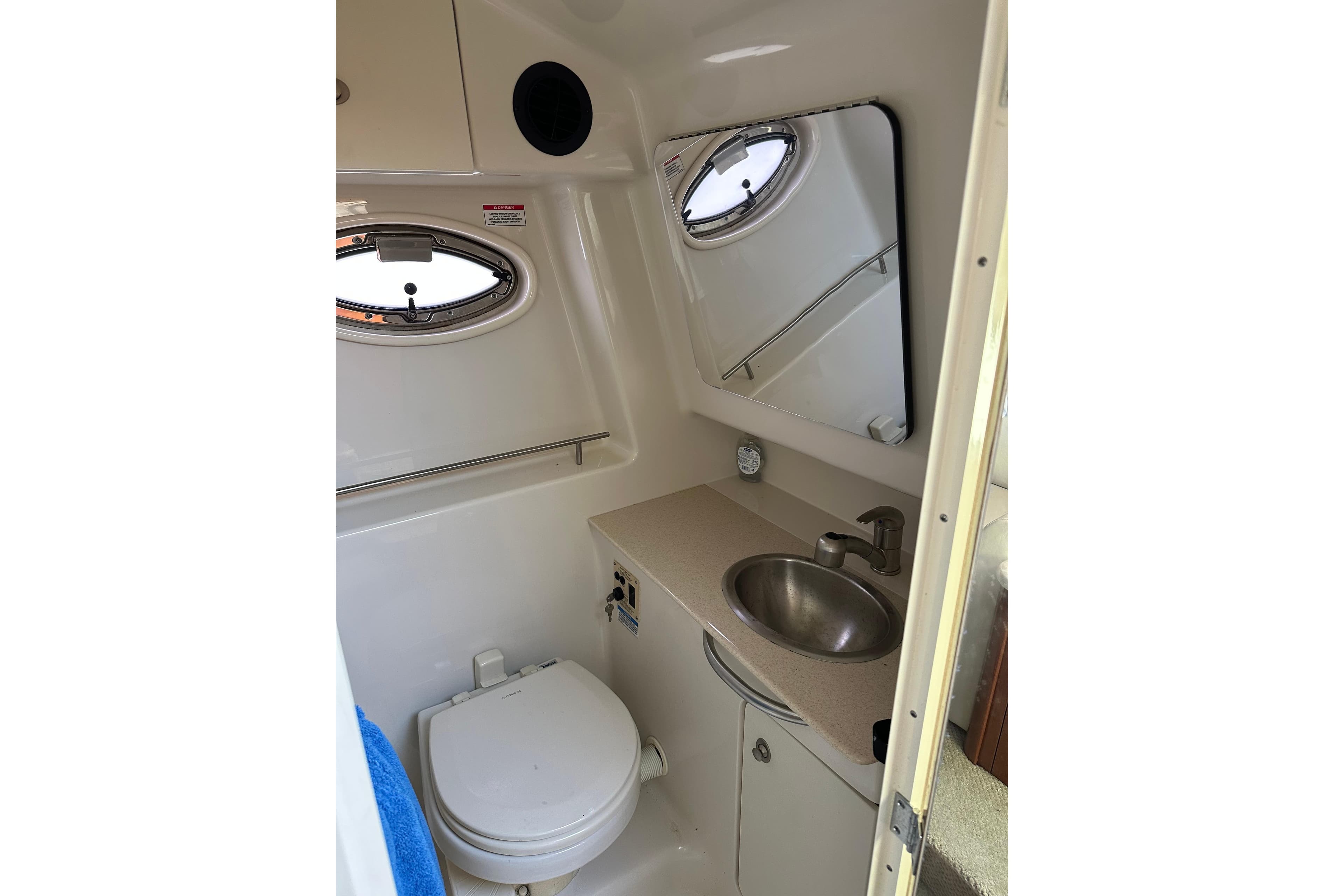 Compact bathroom in 2008 Sea Ray 290 Sundancer boat with sink, toilet, and mirror.