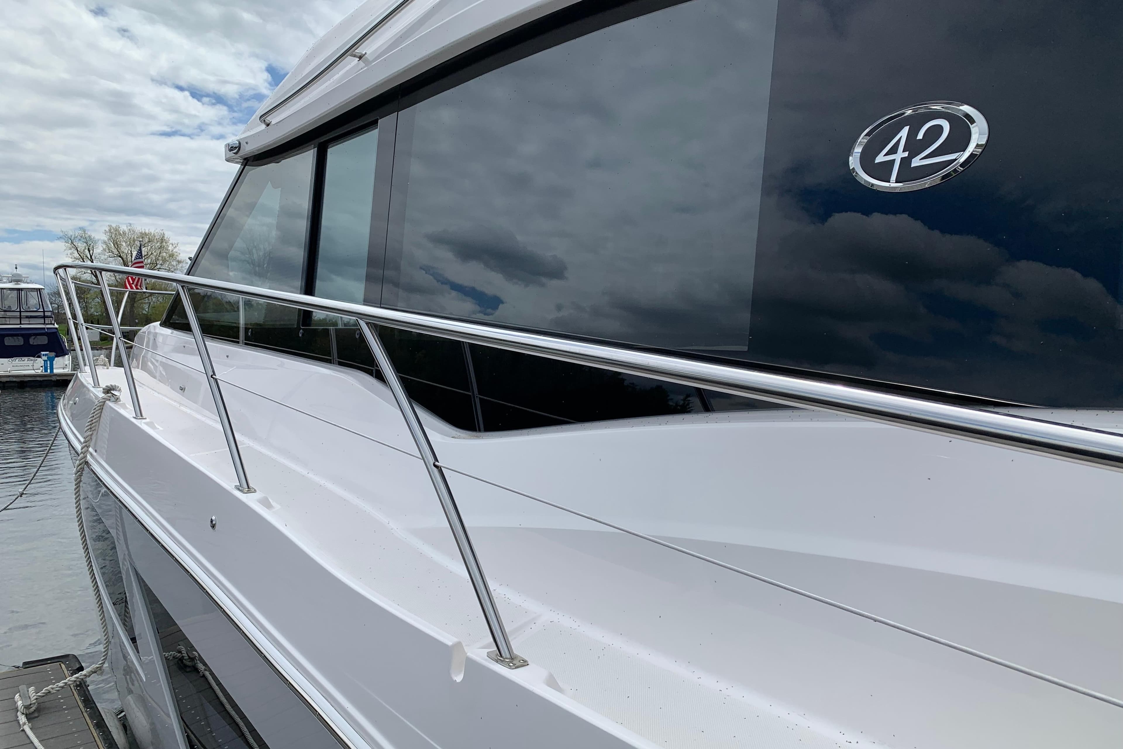 2019 Regal 42 Grande Coupe yacht docked, showcasing sleek design and reflective windows.