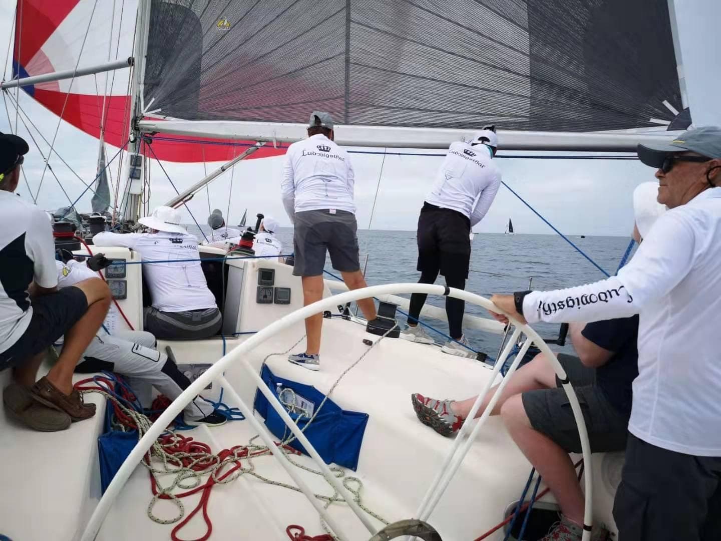 Sailors maneuvering a BH 41 yacht during a race, showcasing teamwork and skill.