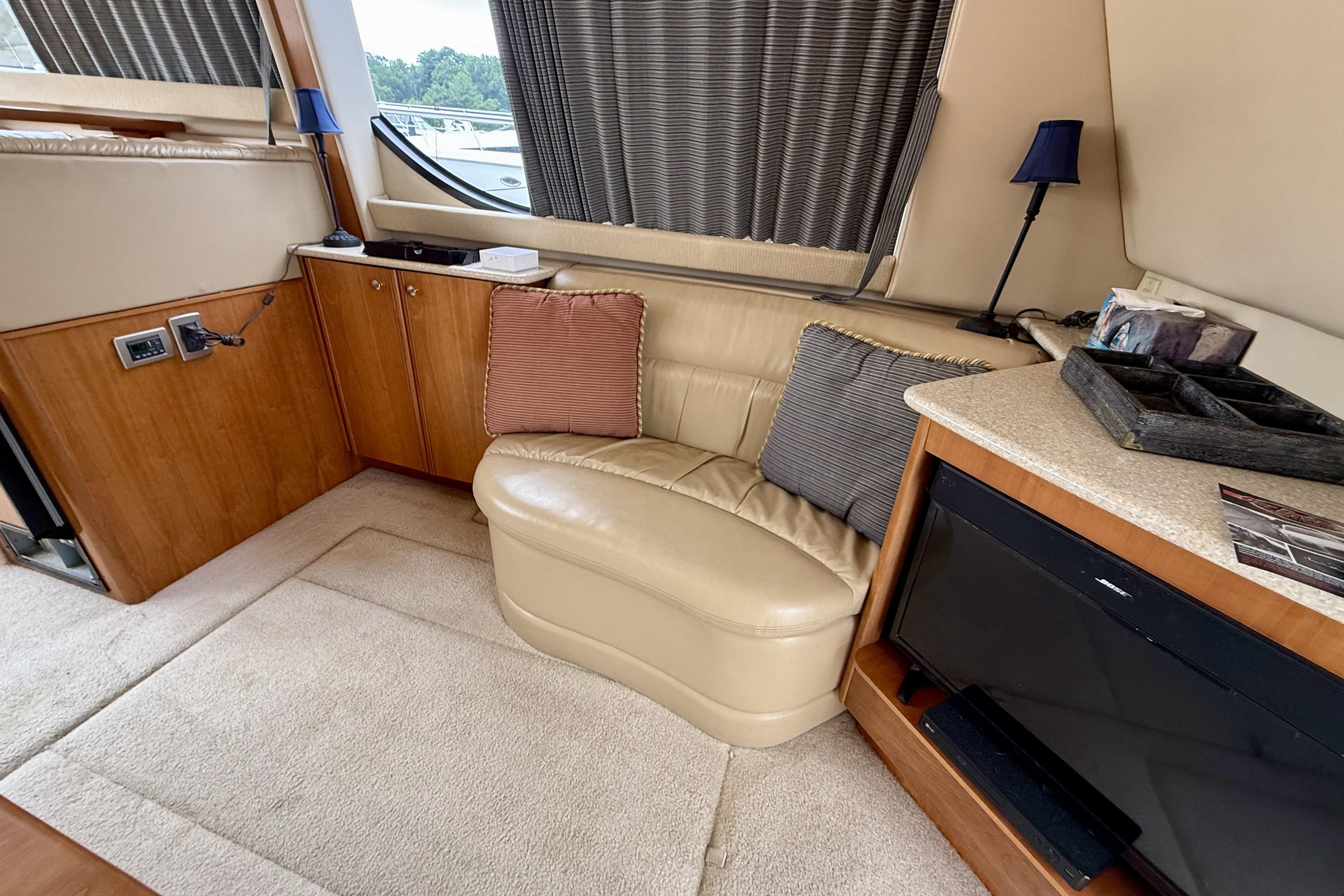 Interior of a 2004 Meridian 381 Sedan yacht with beige seating and wooden cabinetry.
