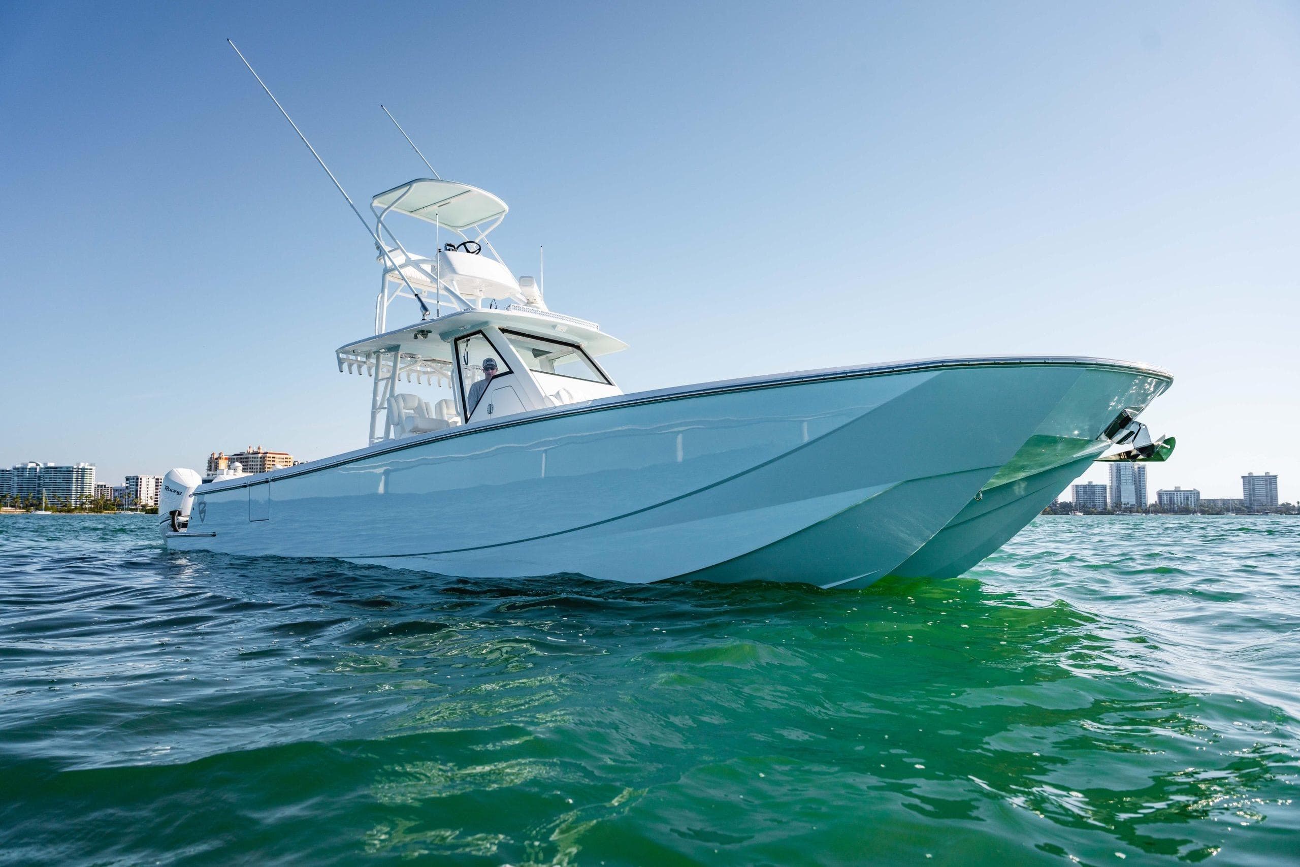2026 Barker Boatworks 40HPC cruising on clear blue water near city skyline.