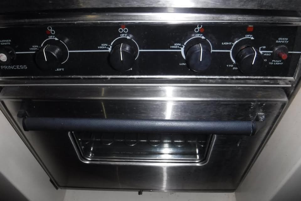 Stainless steel oven with control knobs, labeled "Princess," in a 1986 Fast Masthead Sloop.