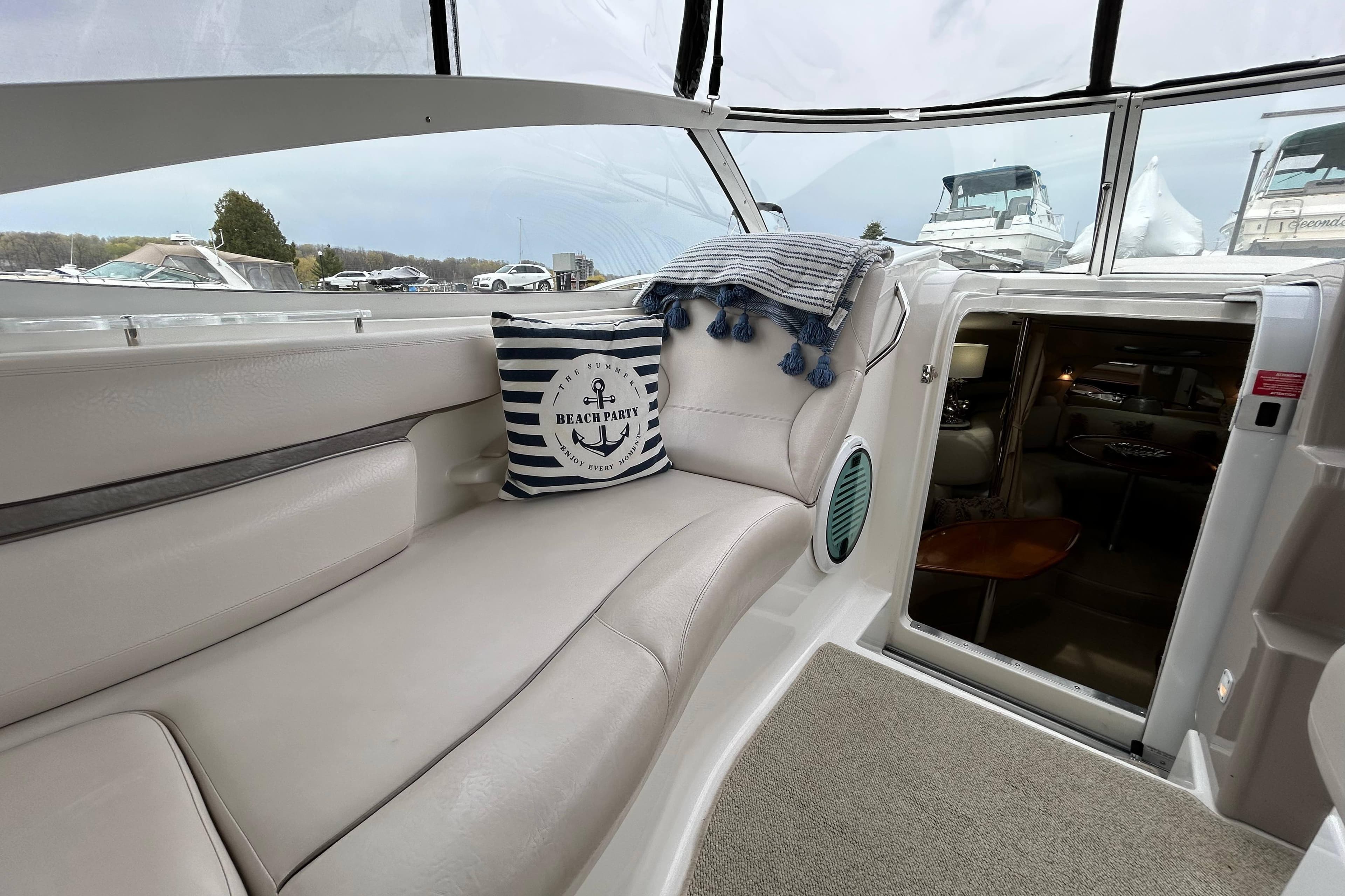Interior of a 2002 Doral 330se boat with cozy seating and nautical decor.