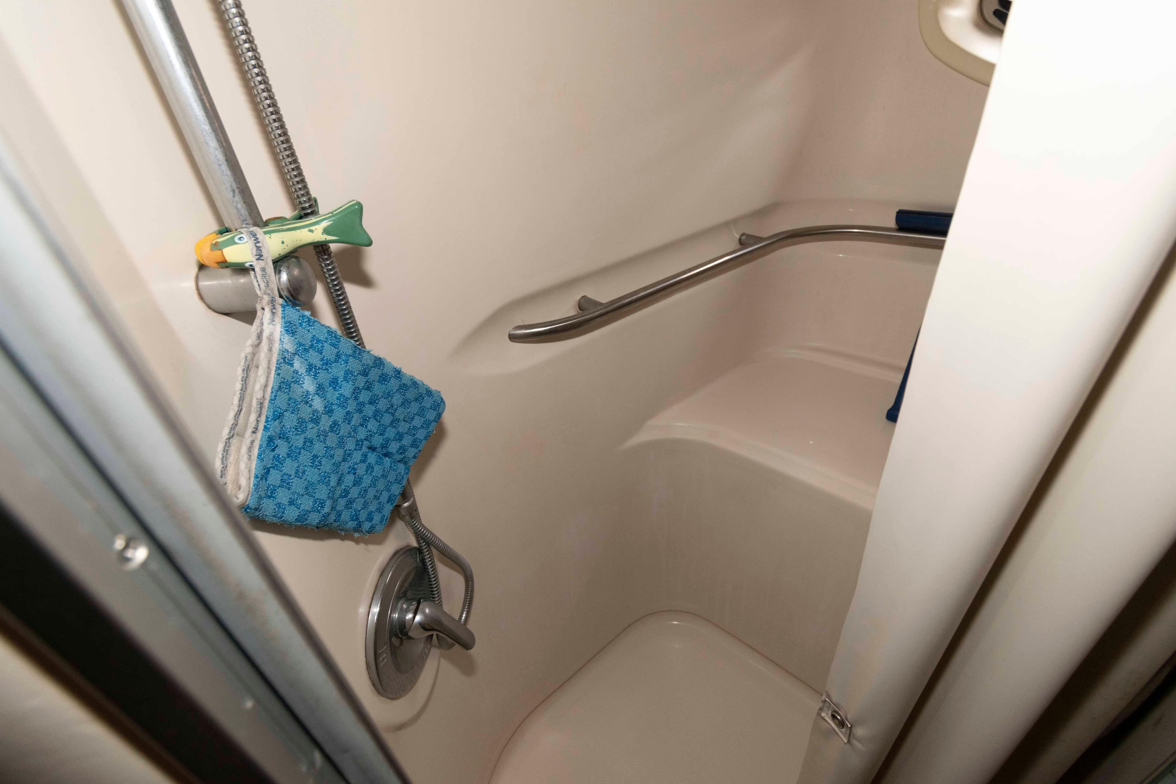 Shower area in 2000 Maxum 4100 SCA boat with blue washcloth and fish-shaped hook.