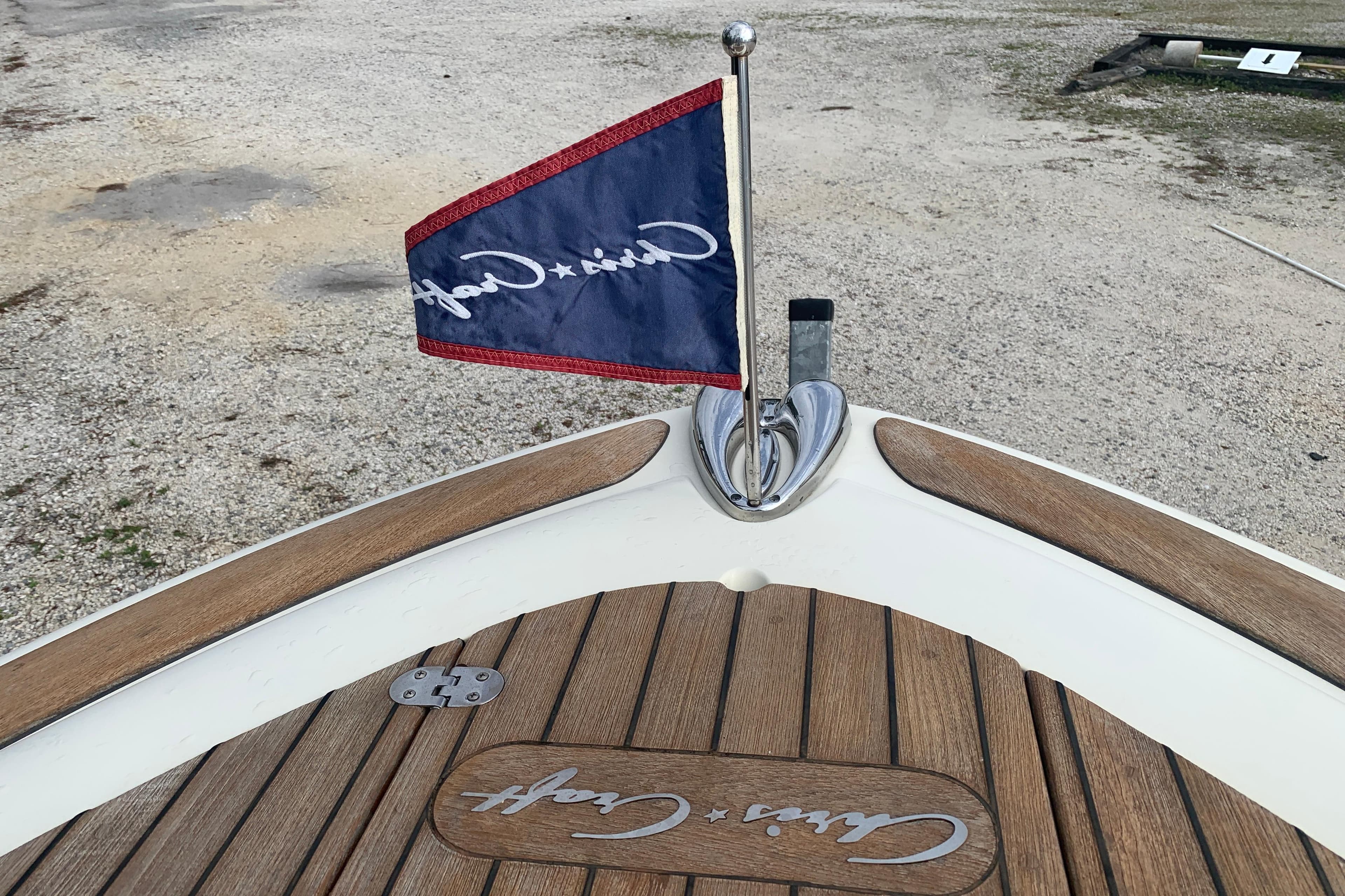 2019 Chris-Craft Catalina 27 boat with branded flag and wooden deck detail.