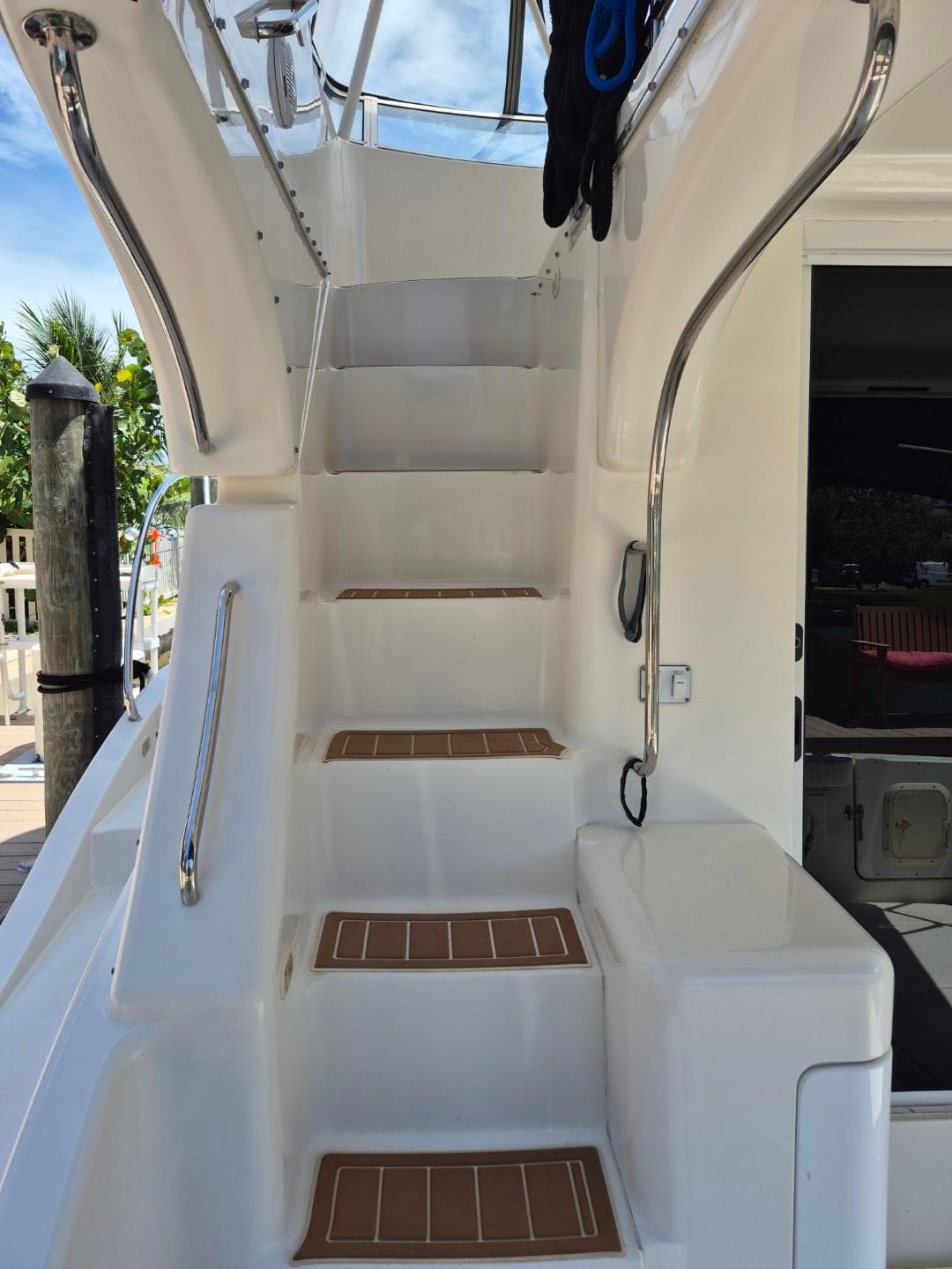 Staircase on a 2002 Silverton 38 Convertible yacht, featuring sleek design and stainless steel railings.