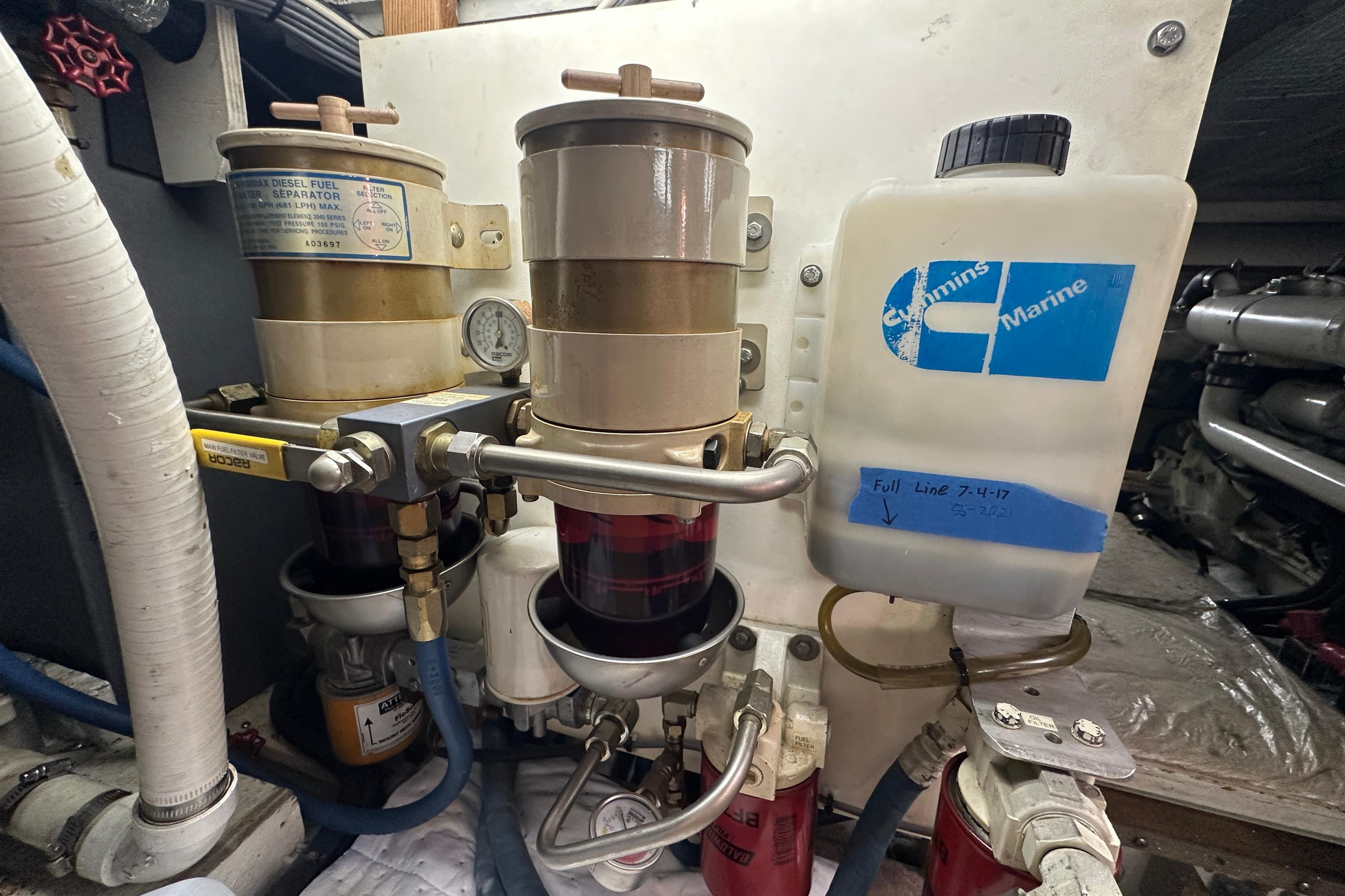 Engine room of 1972 Tollycraft 42 Tri-Cabin with fuel filters and Cummins Marine container.