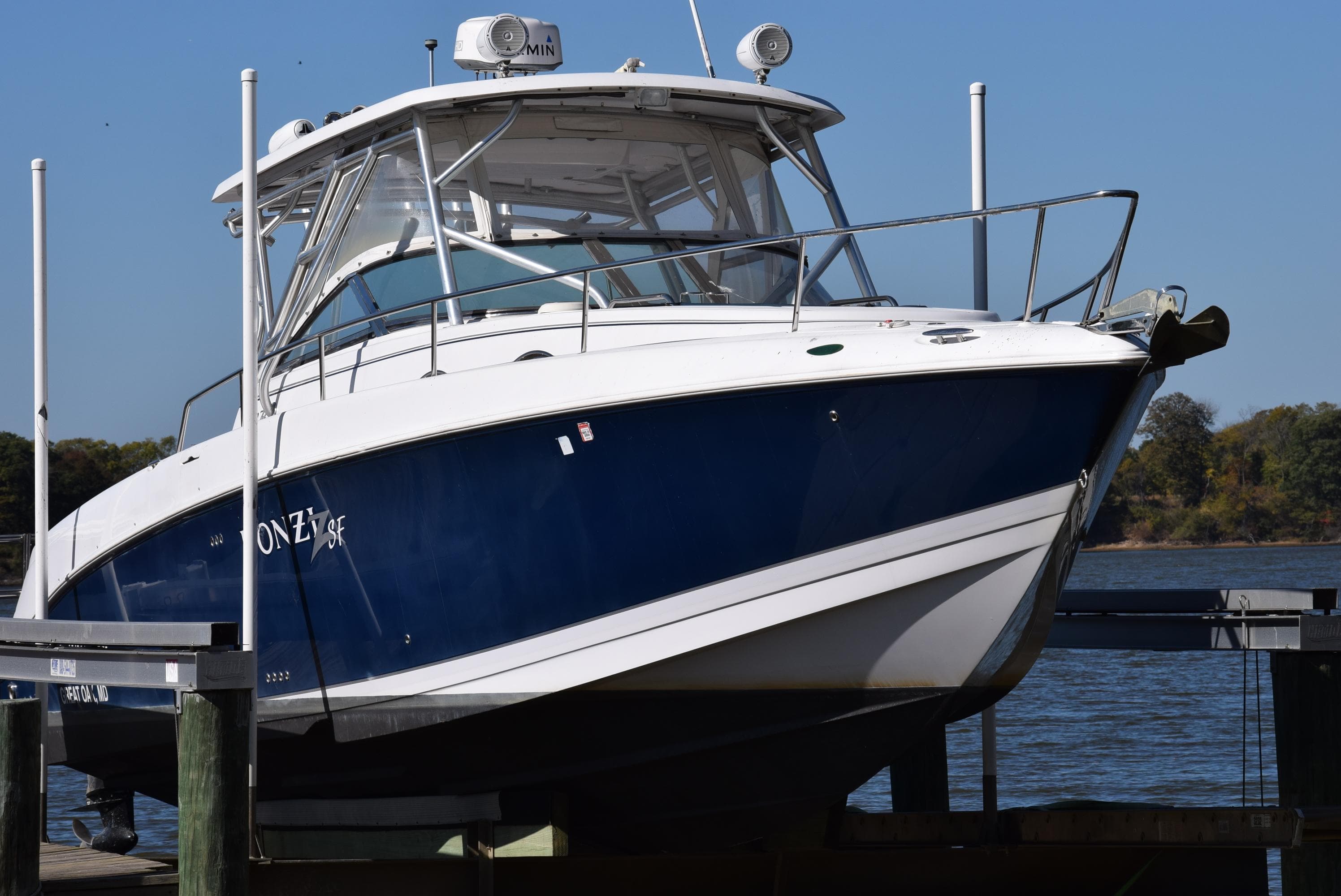 2005 Donzi 38 ZSF boat docked by the water on a sunny day.