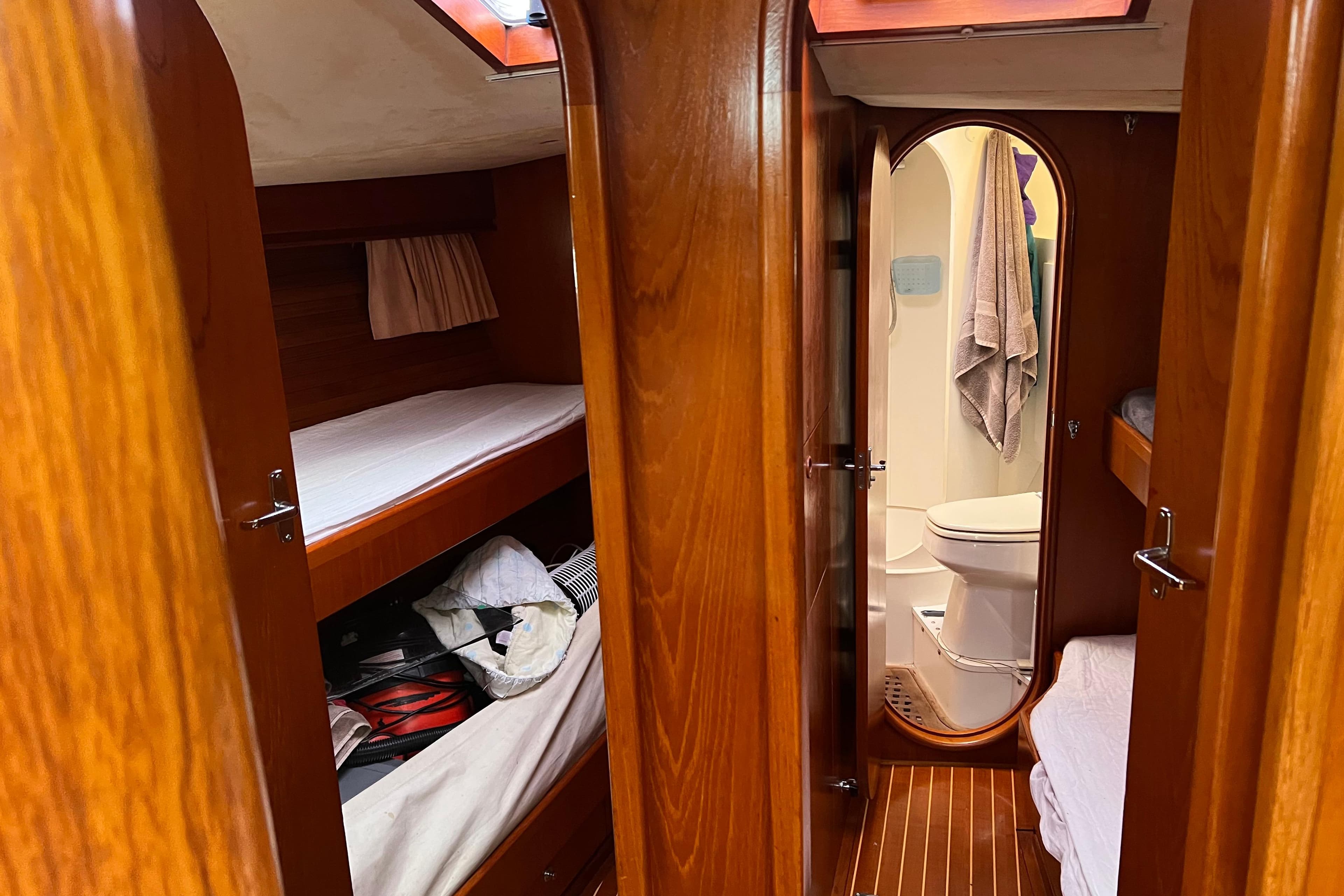 Interior of 1990 Trintella 49A yacht with wooden finish, bunk beds, and bathroom.