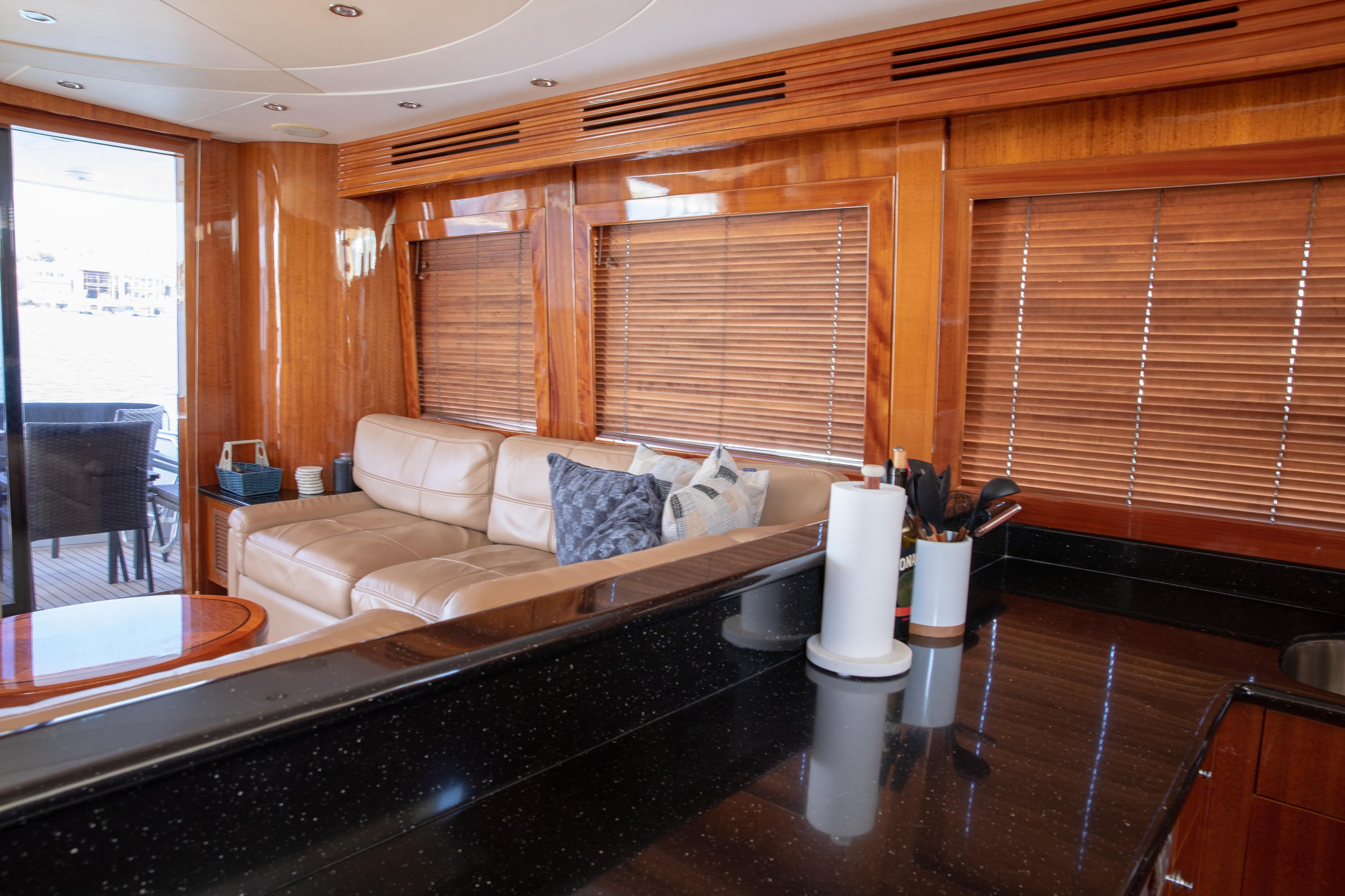 Luxurious interior of 2002 Hatteras 63 Raised Pilothouse Motor Yacht with leather seating and wooden blinds.