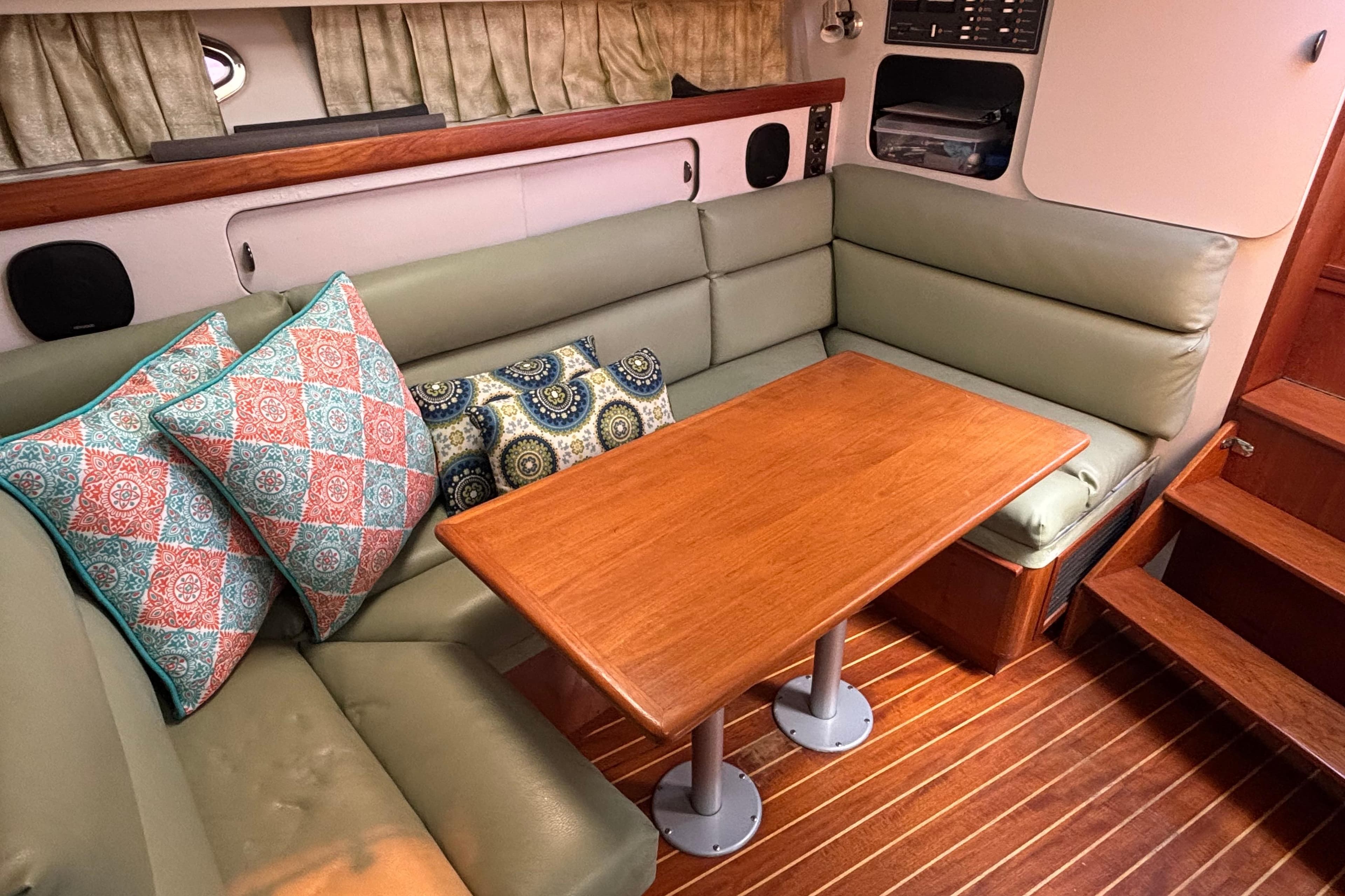 Interior of 1991 Tiara Yachts 3100 Open with cushioned seating and wooden table.