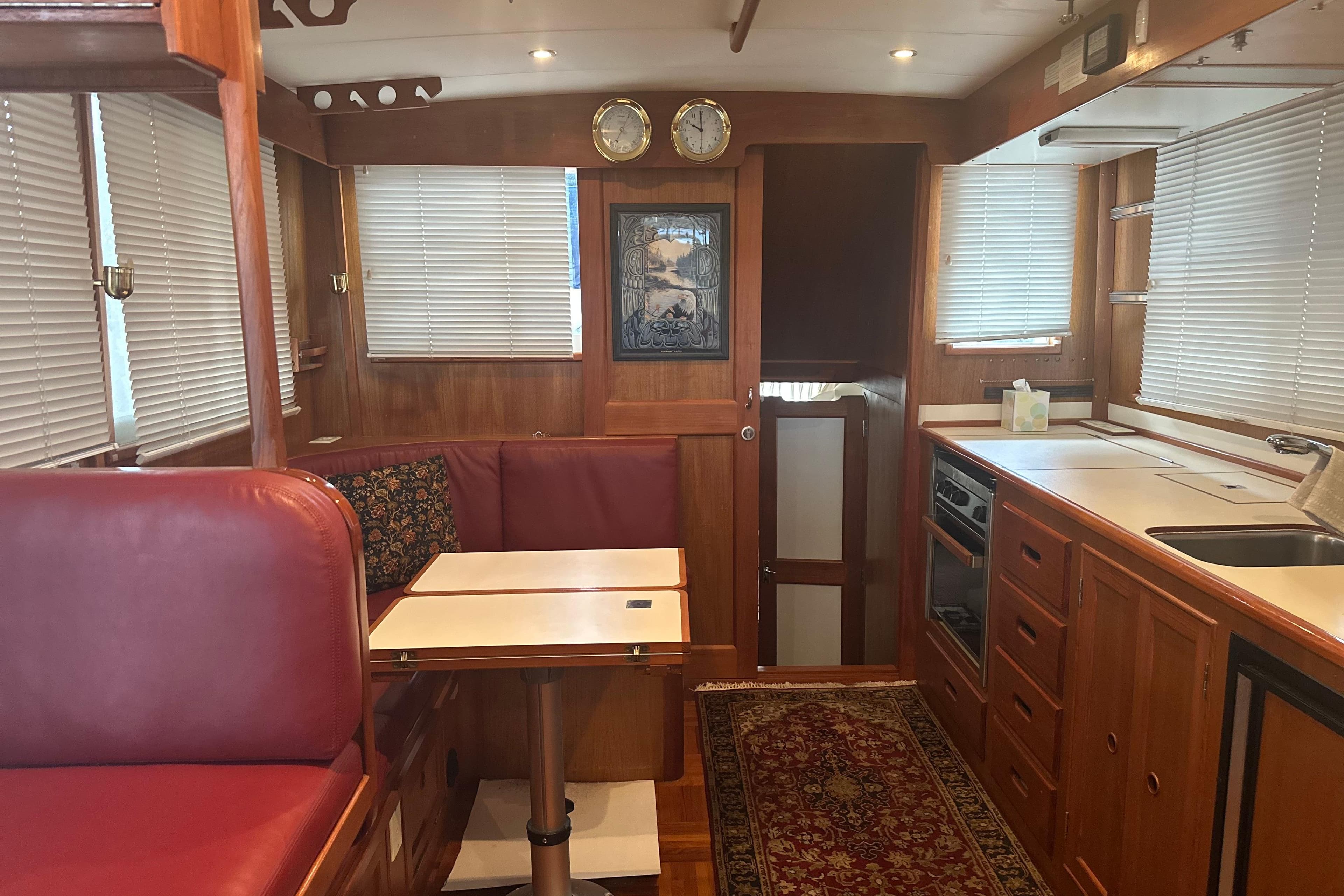 Interior of 2000 Island Gypsy 36 yacht with wood finish and red seating.