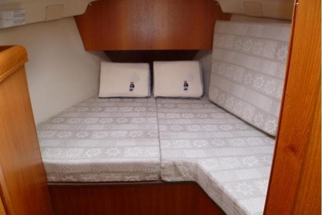 2002 Hunter 326 boat interior cabin with cushioned bed and wooden accents.