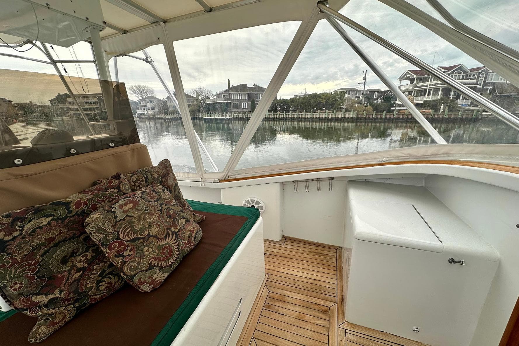 1987 Palm Beach 30 Express boat interior with cushions, wooden flooring, and waterfront view.