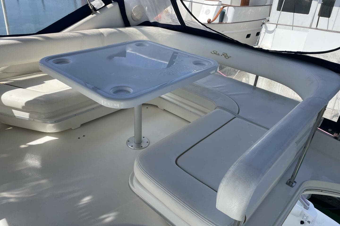 2000 Sea Ray 400 Sedan Bridge interior with white seating and table.