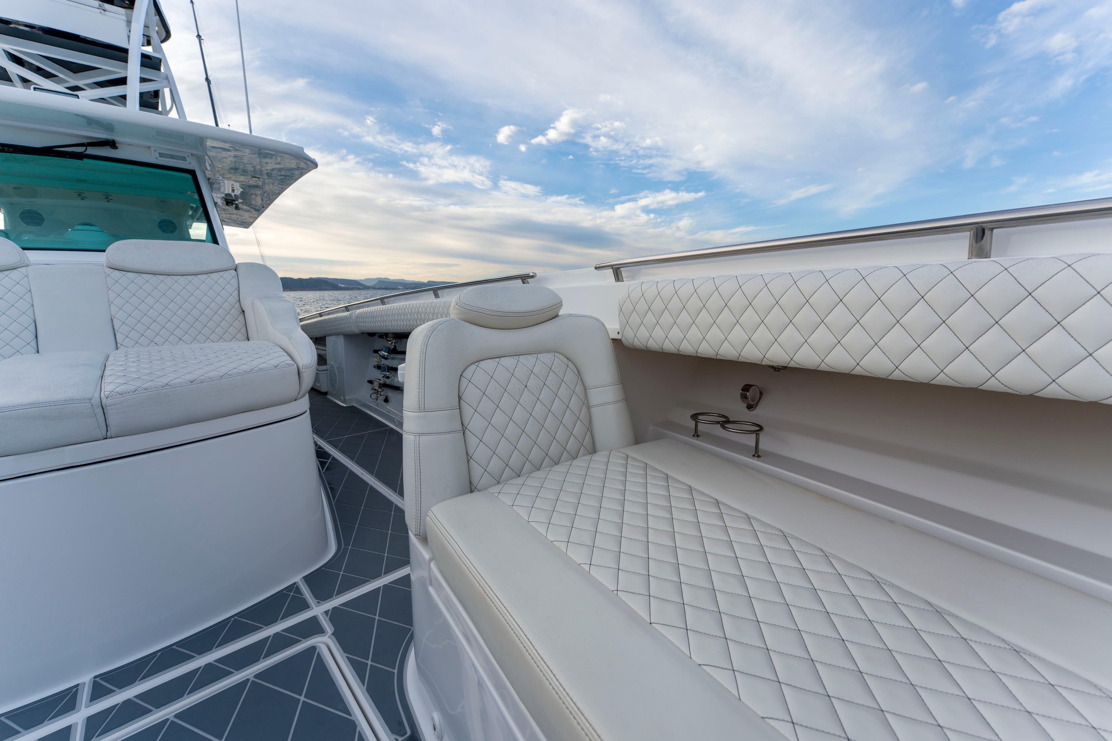 Luxurious seating on 2022 HCB 53 Suenos RXV boat with quilted upholstery and ocean view.