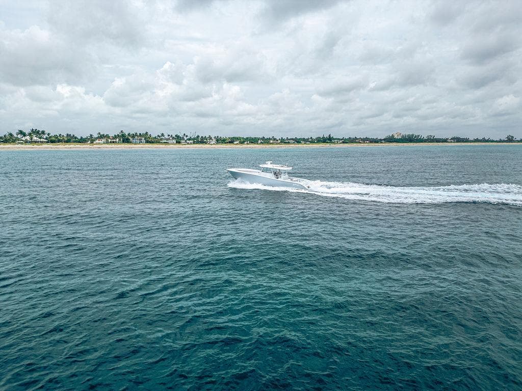 2019 Yellowfin 42 boat cruising on open water near a tropical shoreline.