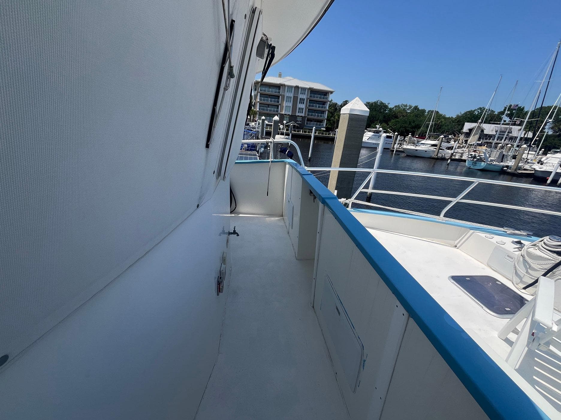 Side deck of 2001 Great Harbour GH47 yacht at marina, clear sky, calm water.