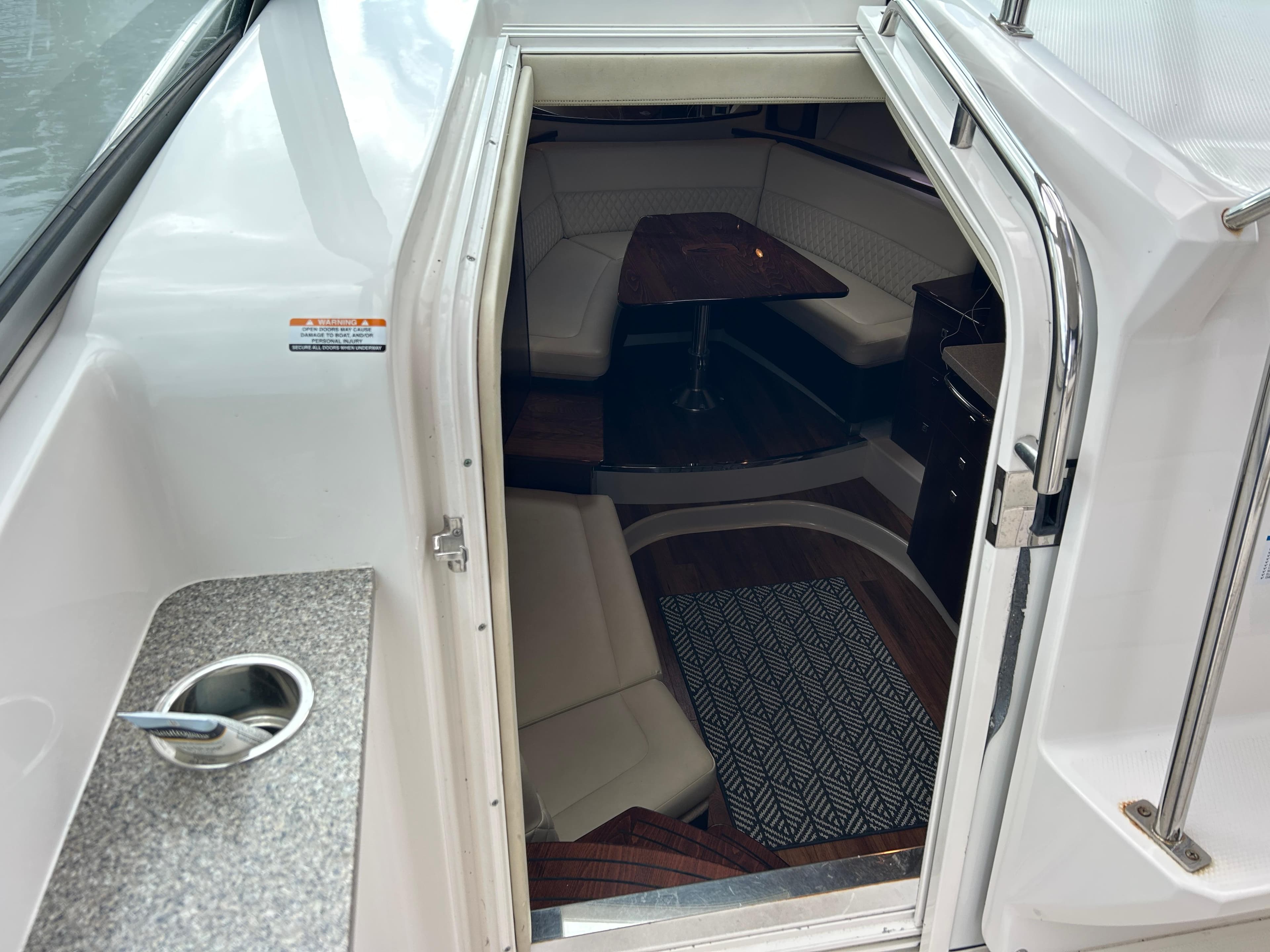 2015 Chaparral 330 Signature cabin entrance with seating and table visible inside.