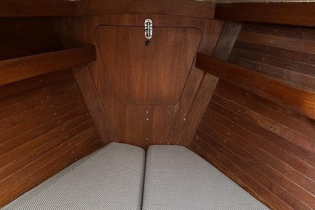 1987 J Boats J28 interior cabin with wooden paneling and cushioned seating.