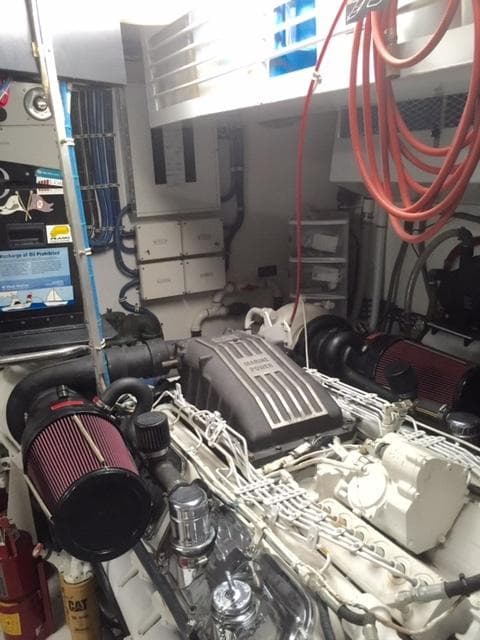 Engine room of a 1998 Hatteras 74 Sport Deck yacht with visible machinery.