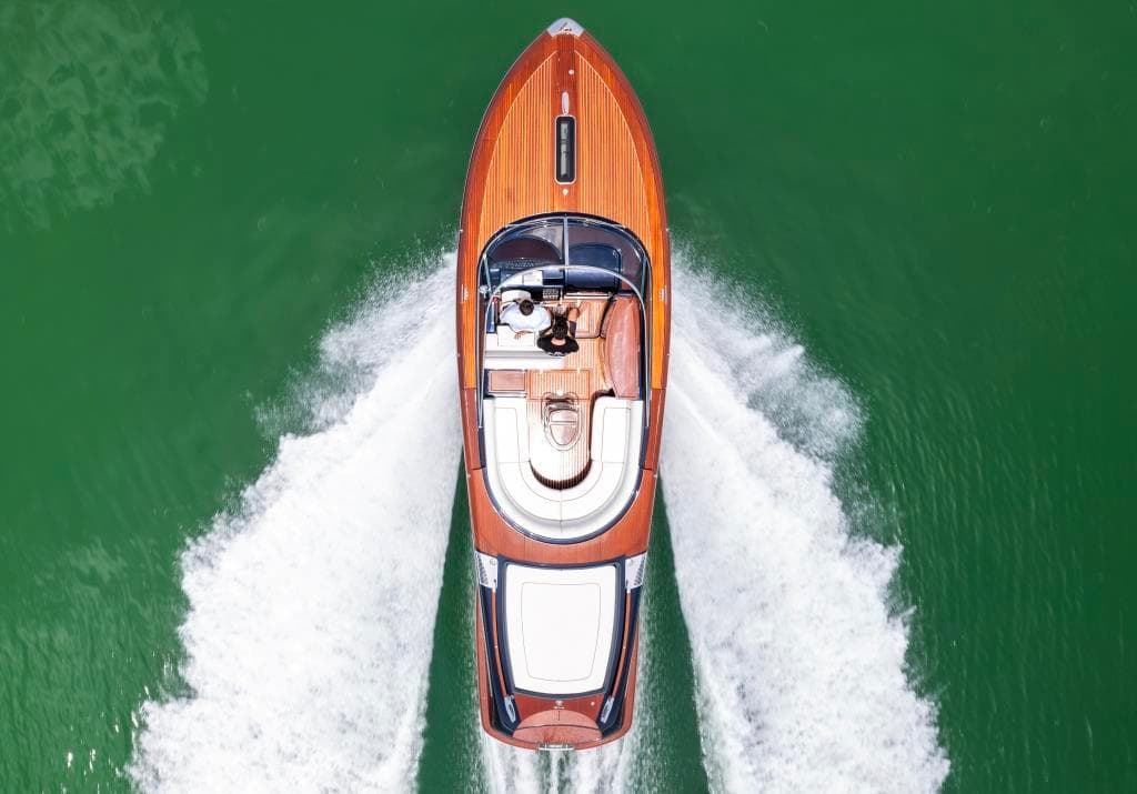 Top view of 2020 Riva Aquariva Super luxury yacht cruising on green water.
