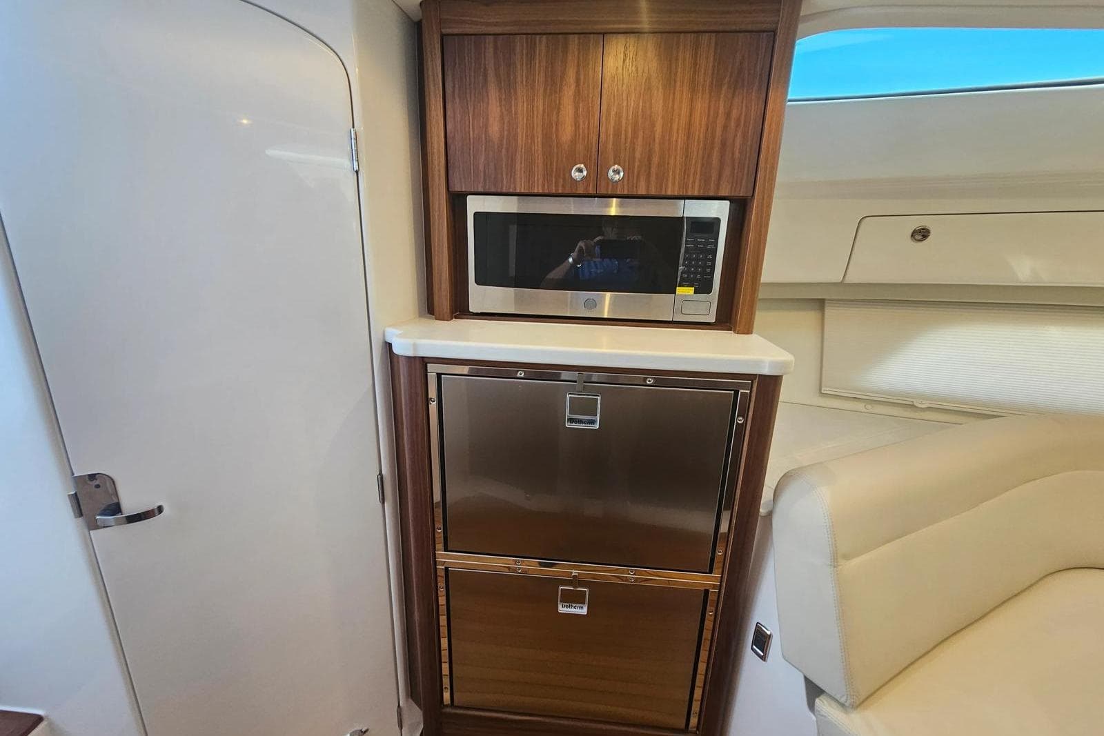 2026 Intrepid 438 Evolution yacht interior with microwave and storage cabinets.