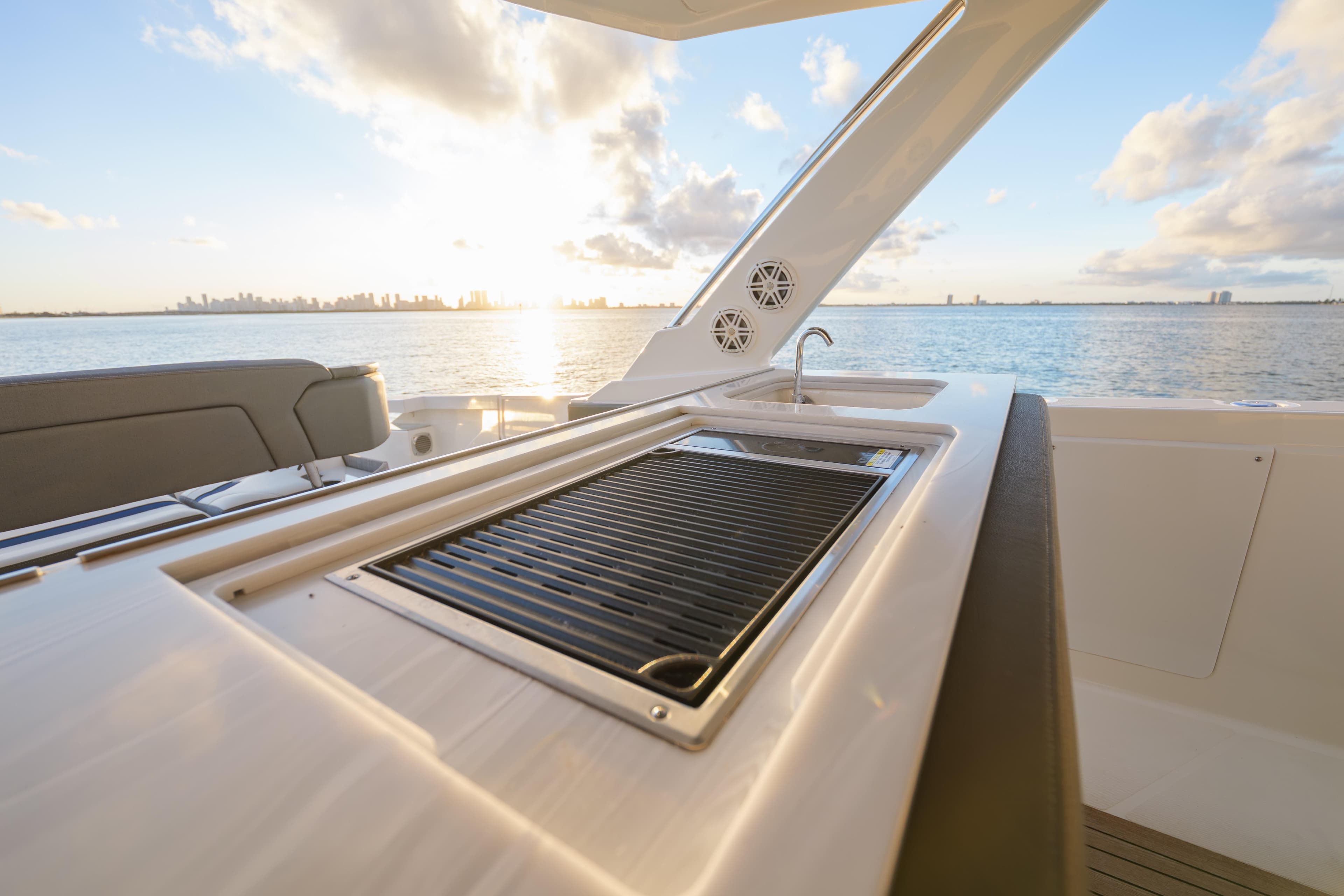 Luxury Tiara Yachts 43 LS 2020 with outdoor grill and ocean view at sunset.
