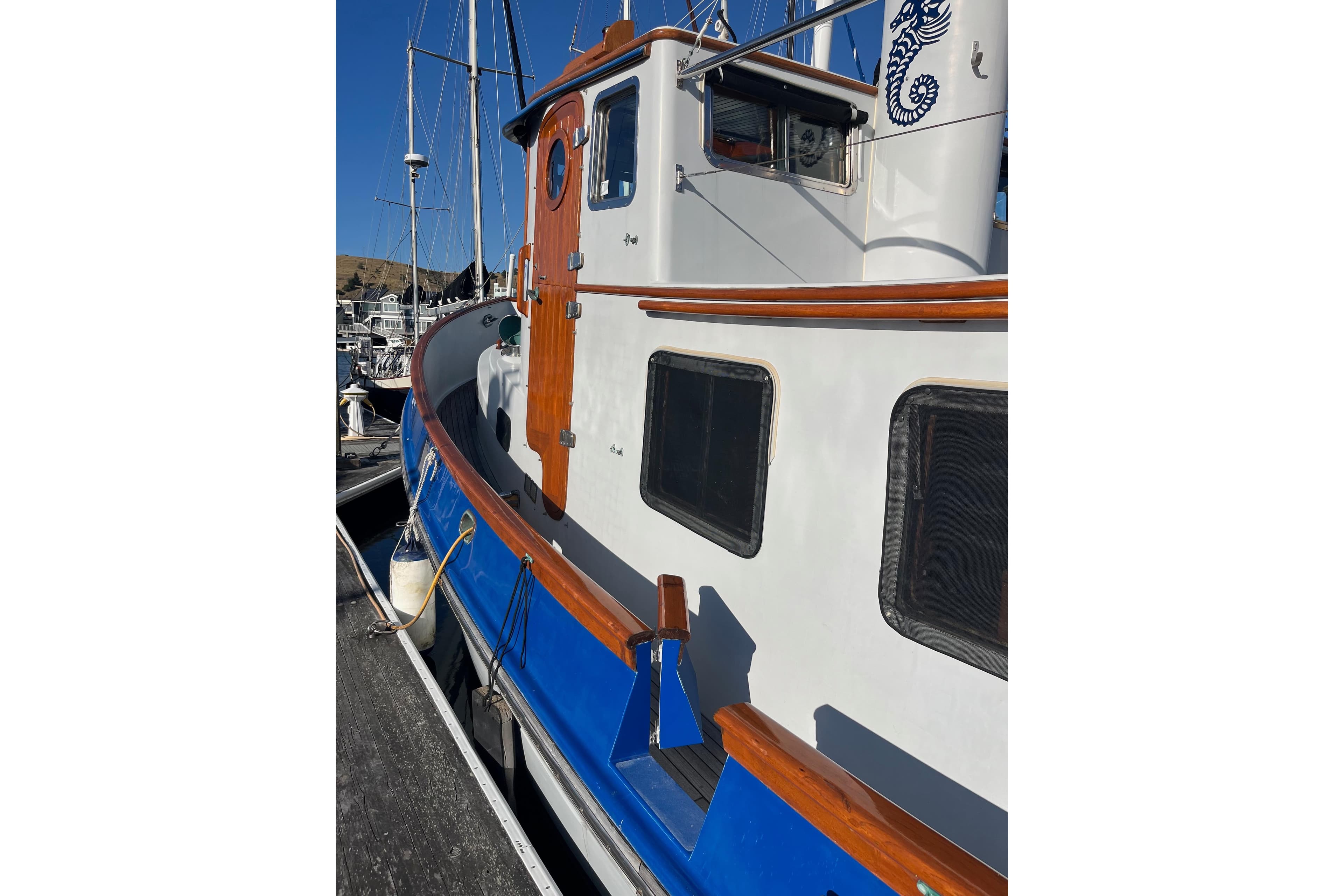1987 Lord Nelson Victory Tug boat with wooden accents docked at marina.