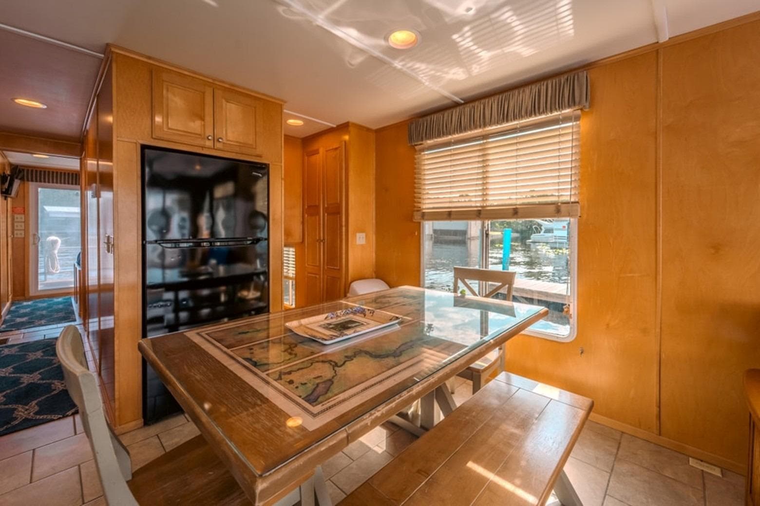 Dining area inside 2014 Sunstar Houseboats 55, featuring wooden table and window view.