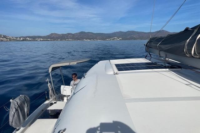 Sailing on a 2021 Excess 11 catamaran with scenic coastal views and clear blue skies.