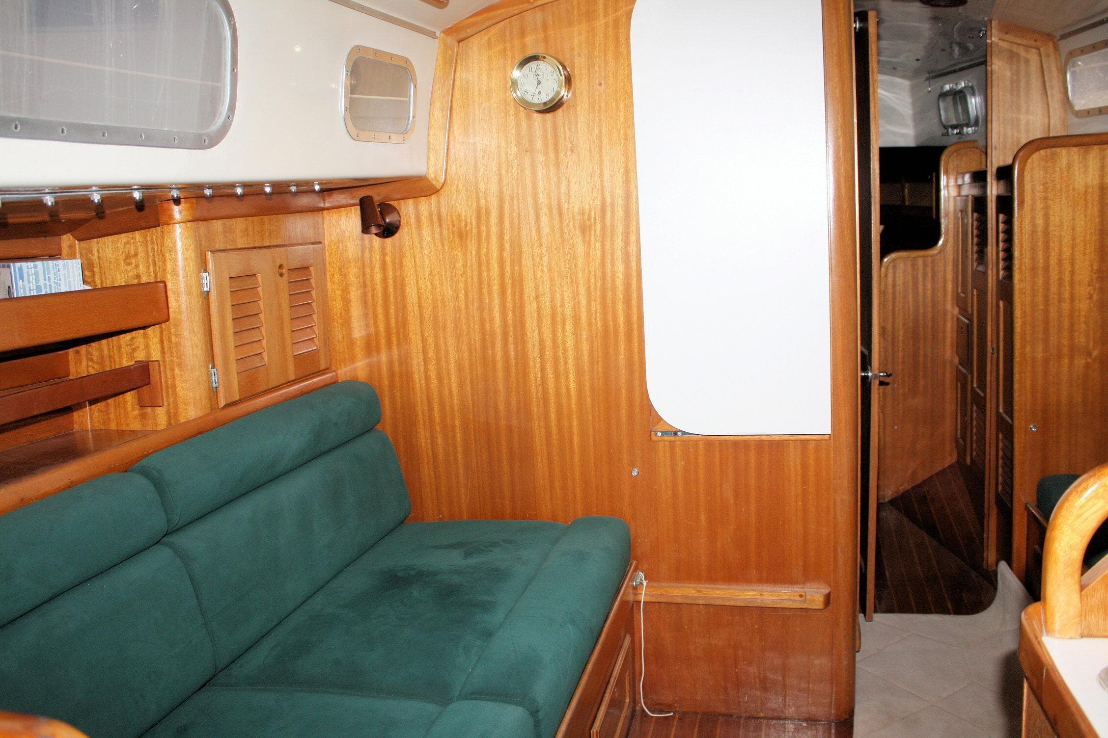 Interior of a 1981 Bristol 40 sailboat with wooden paneling and green seating.