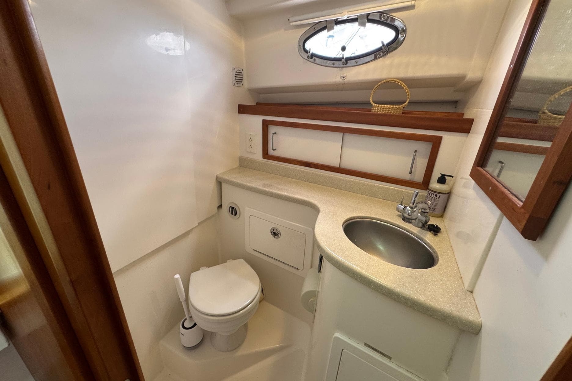 2013 Back Cove 30 yacht bathroom with sink, toilet, and porthole window.