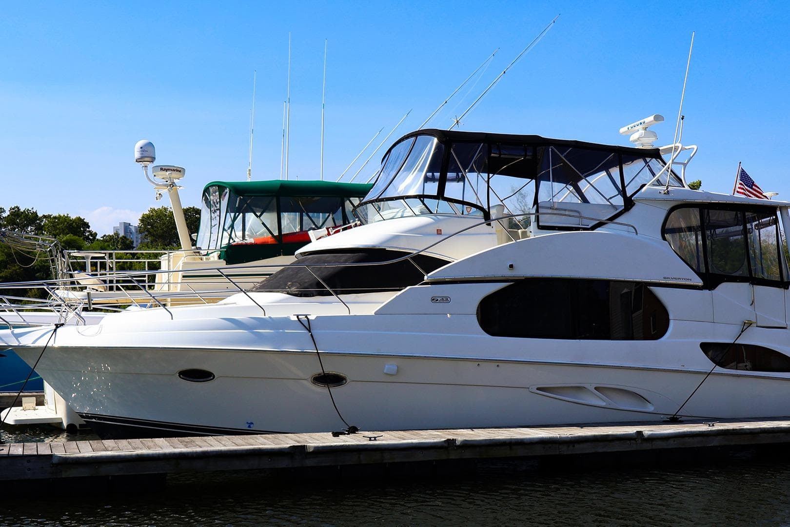 2002 Silverton 43 Motor Yacht docked at marina under clear blue sky.