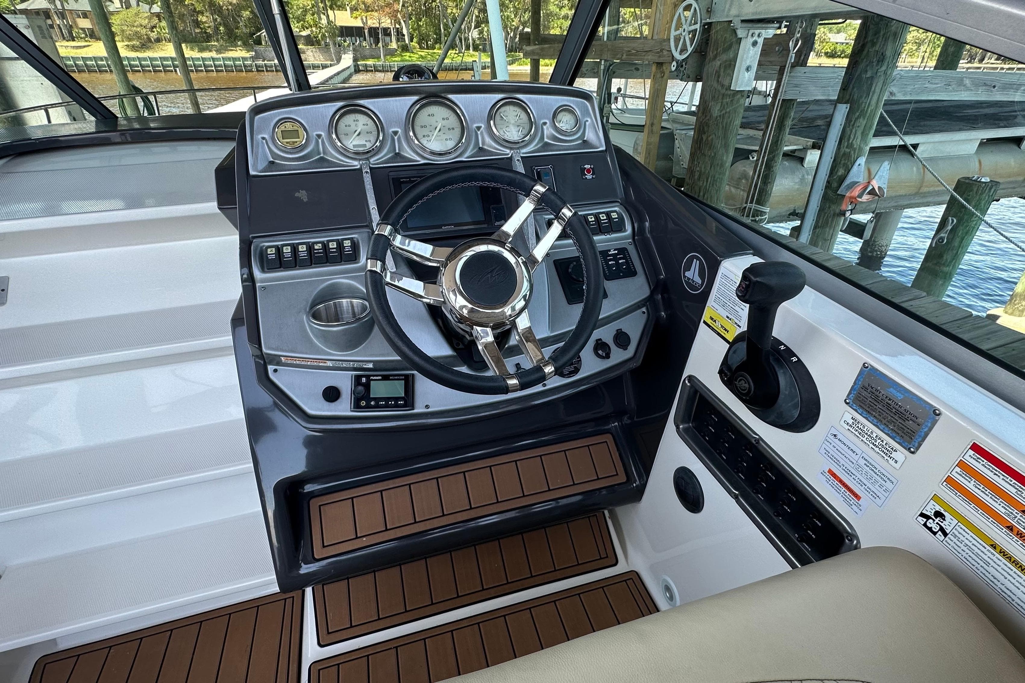 Helm of 2014 Monterey 260 Sport Yacht with modern controls and wood accents.
