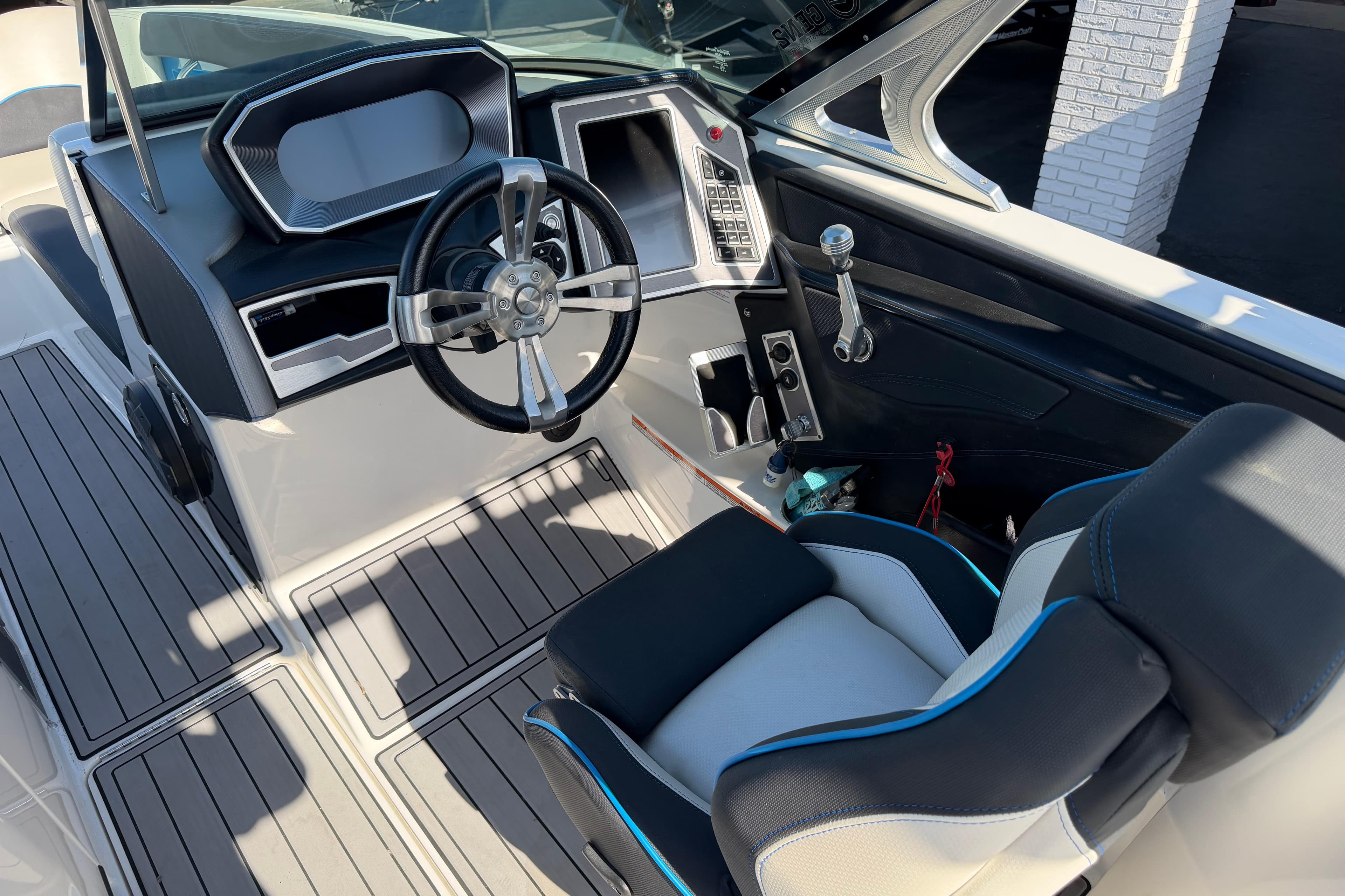 Interior view of 2018 MasterCraft X26 boat cockpit with steering wheel and control panel.