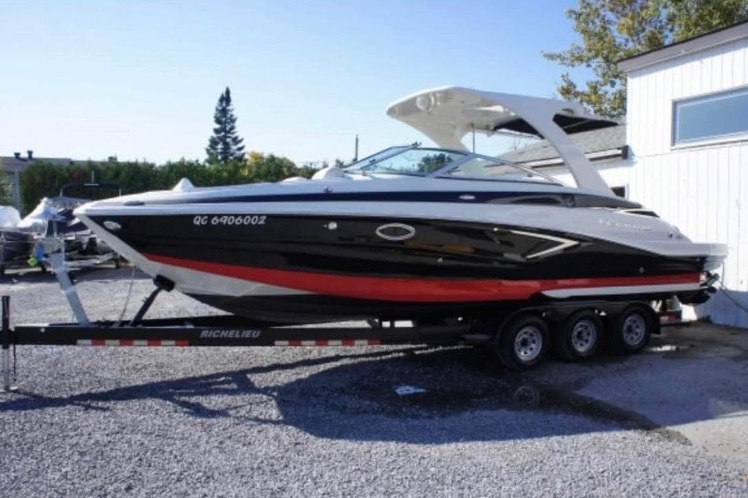2018 Crownline Eclipse E30 boat on trailer, black and red design, parked outdoors.