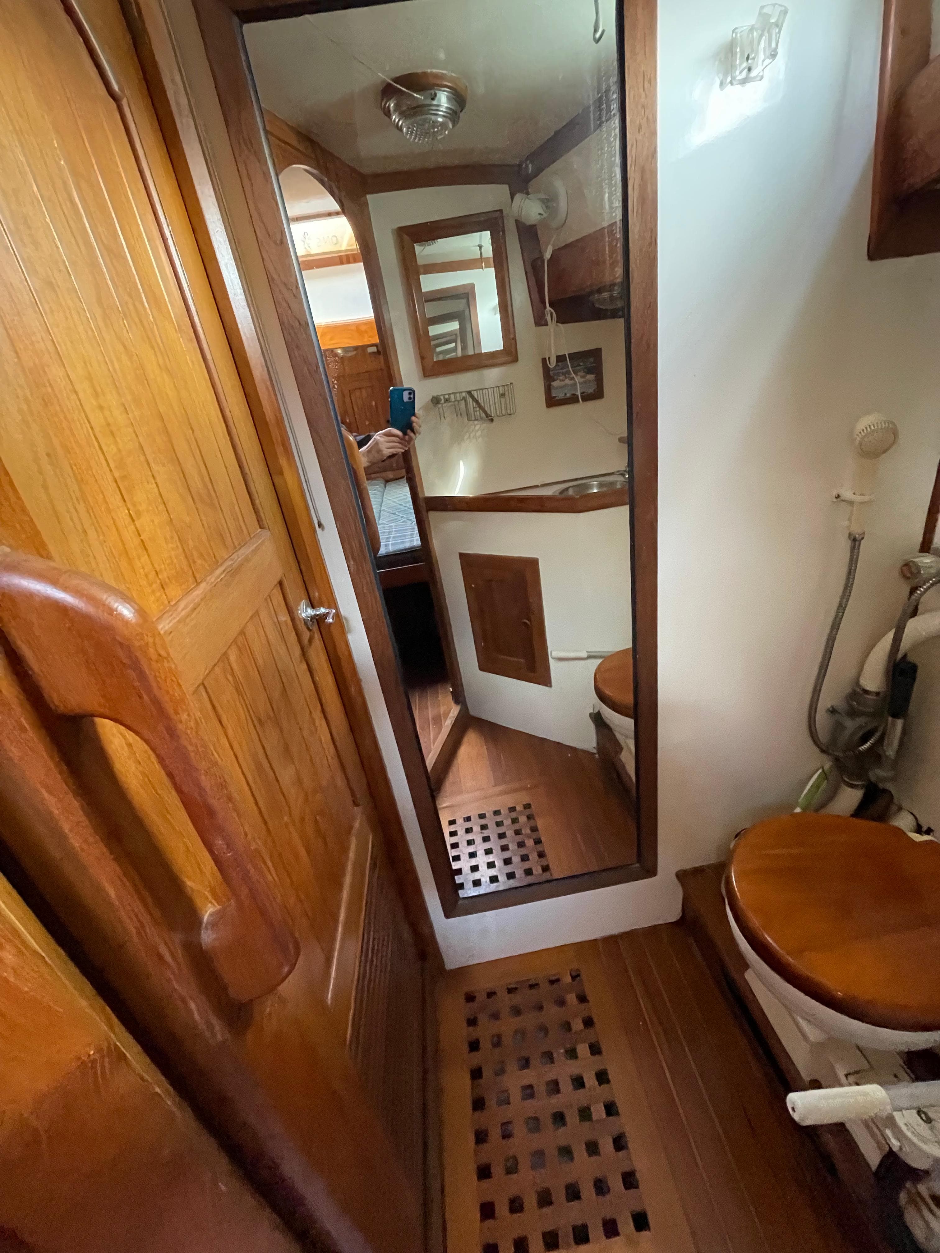 1979 Formosa 46 Cutter yacht bathroom with wooden accents and mirror.