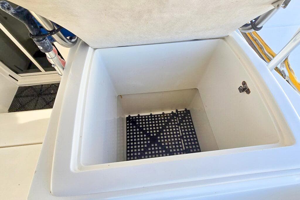 Open storage compartment on a 2006 Dolphin 460 boat, featuring a grid base.