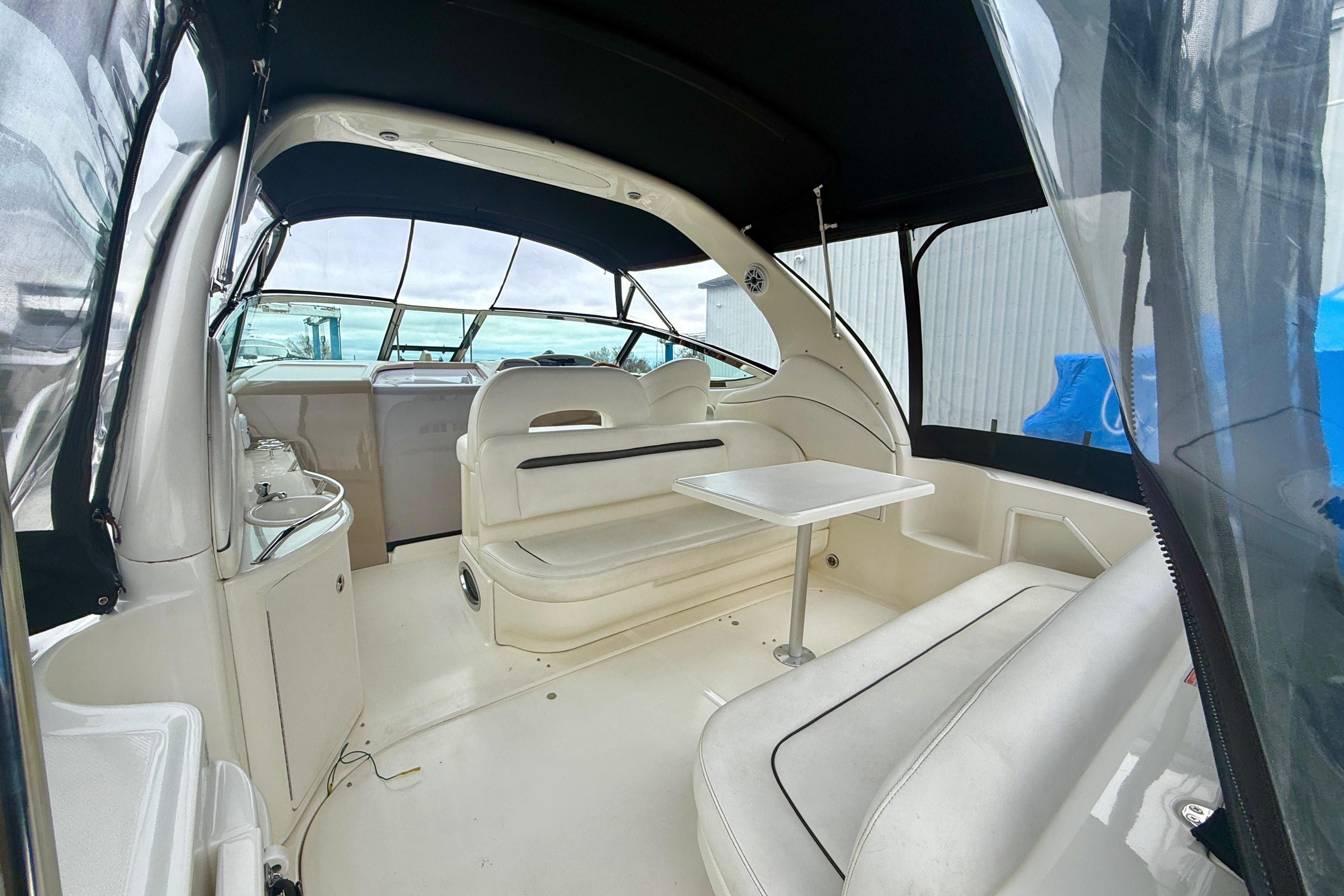 2004 Searay 360 Sundancer interior with seating and table, featuring a sleek design.