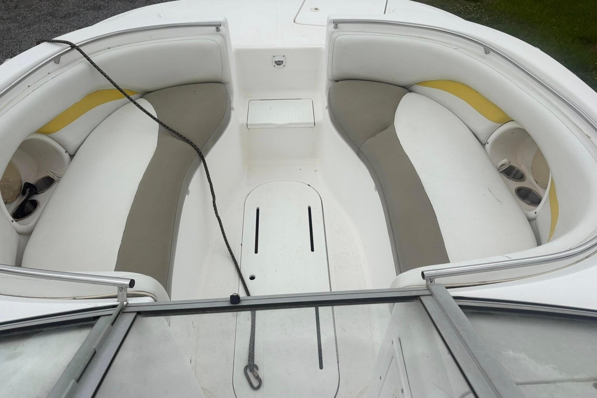 2004 Mariah DX213 boat interior with white and beige seating, cup holders, and rope.