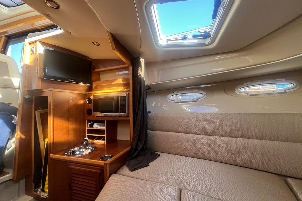 Interior of 2013 Cutwater C-28 boat with kitchenette, TV, and seating area.