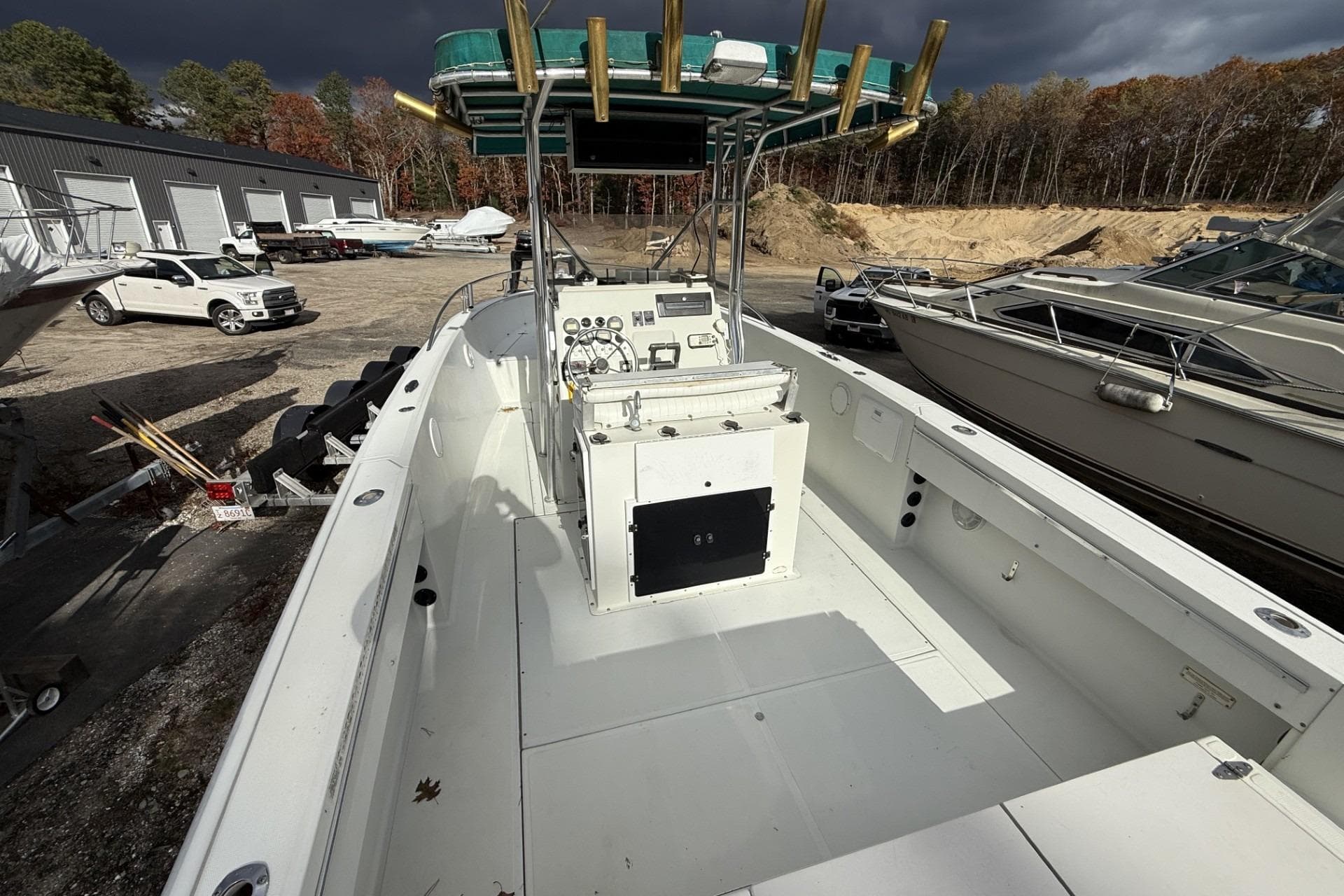 1997 Stamas 270 Tarpon boat with center console, docked outdoors under cloudy skies.