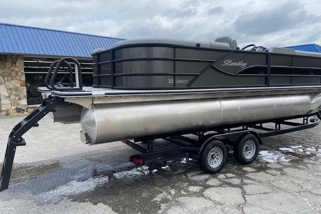 2025 Bentley Pontoons Legacy 220 Navigator on trailer, parked outdoors.