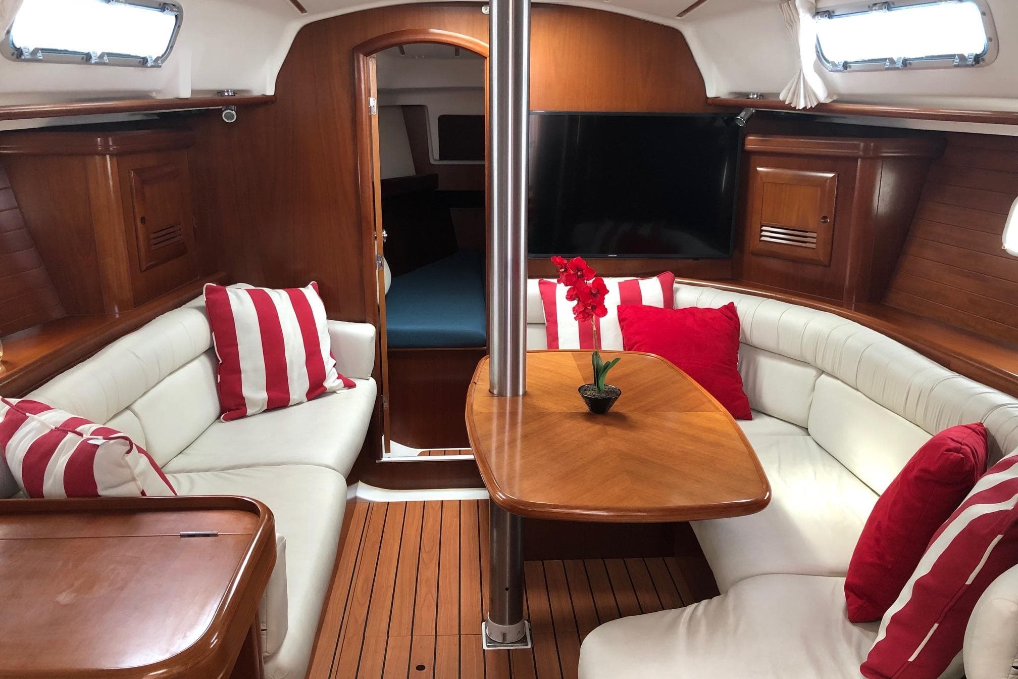 Interior of 2003 Beneteau 361 yacht with cozy seating and striped cushions.