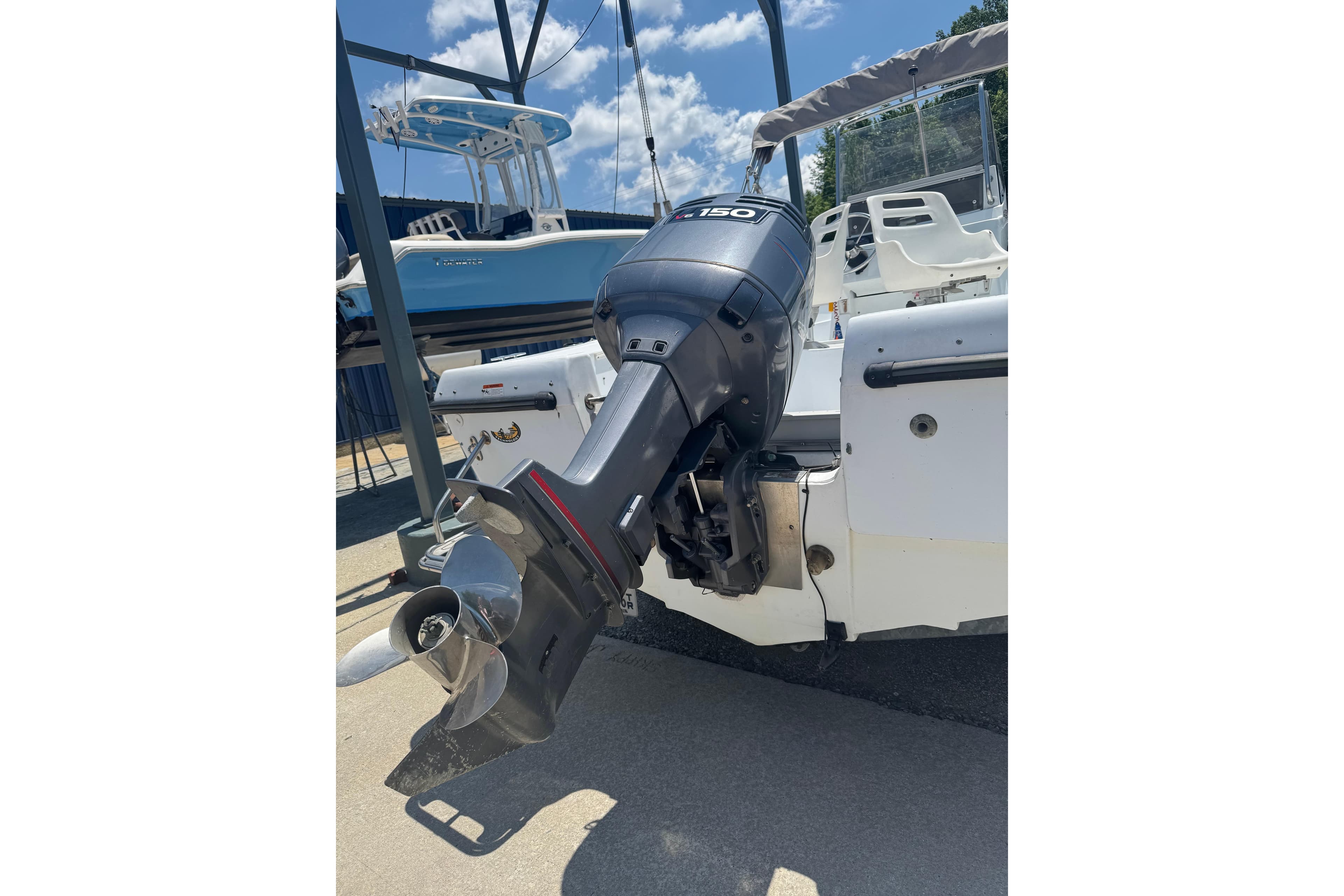 2004 Triumph 210 CC boat with a 150 HP outboard motor, docked under blue skies.