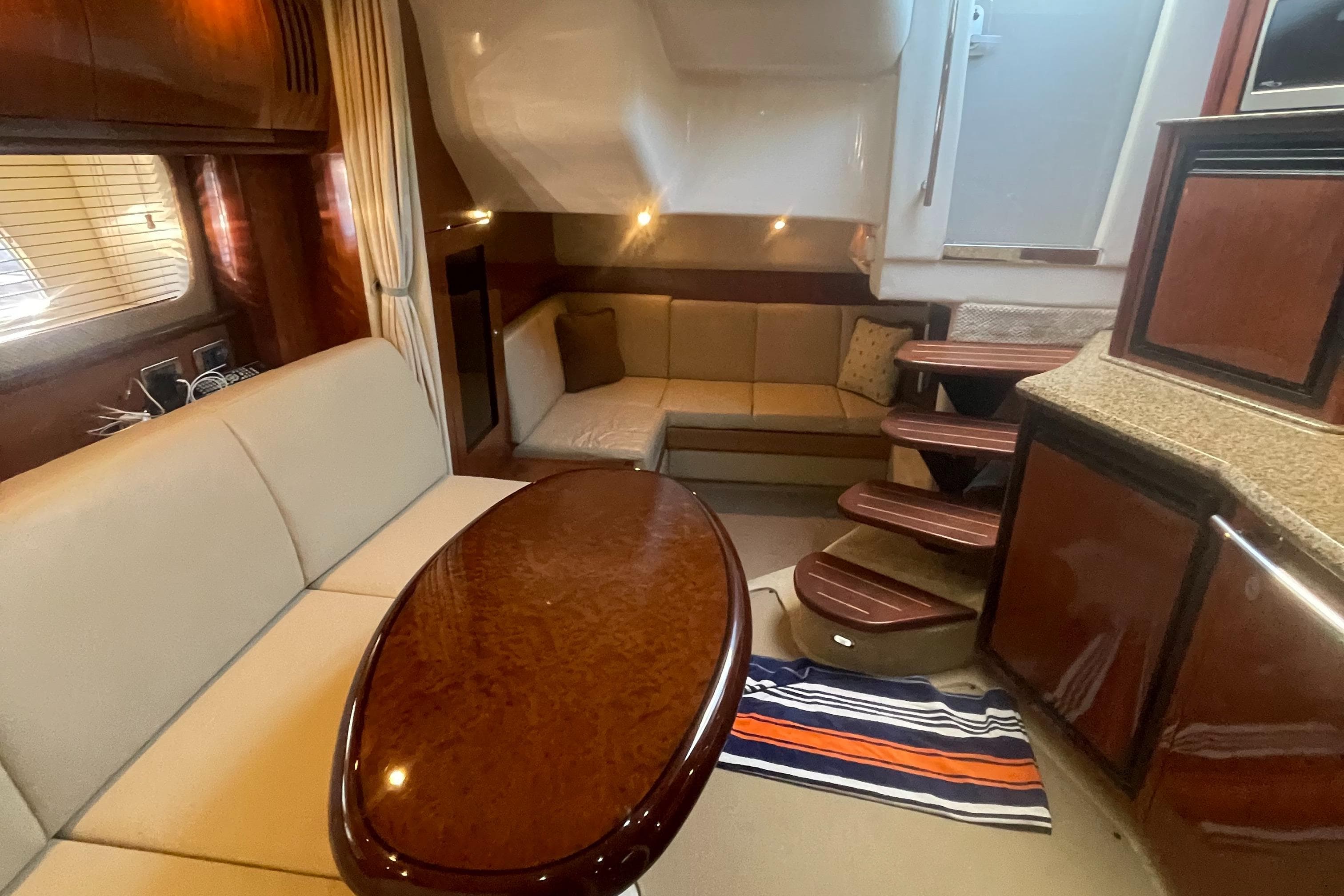 Luxurious interior of 2006 Sea Ray 380 Sundancer yacht with elegant seating and wooden finishes.
